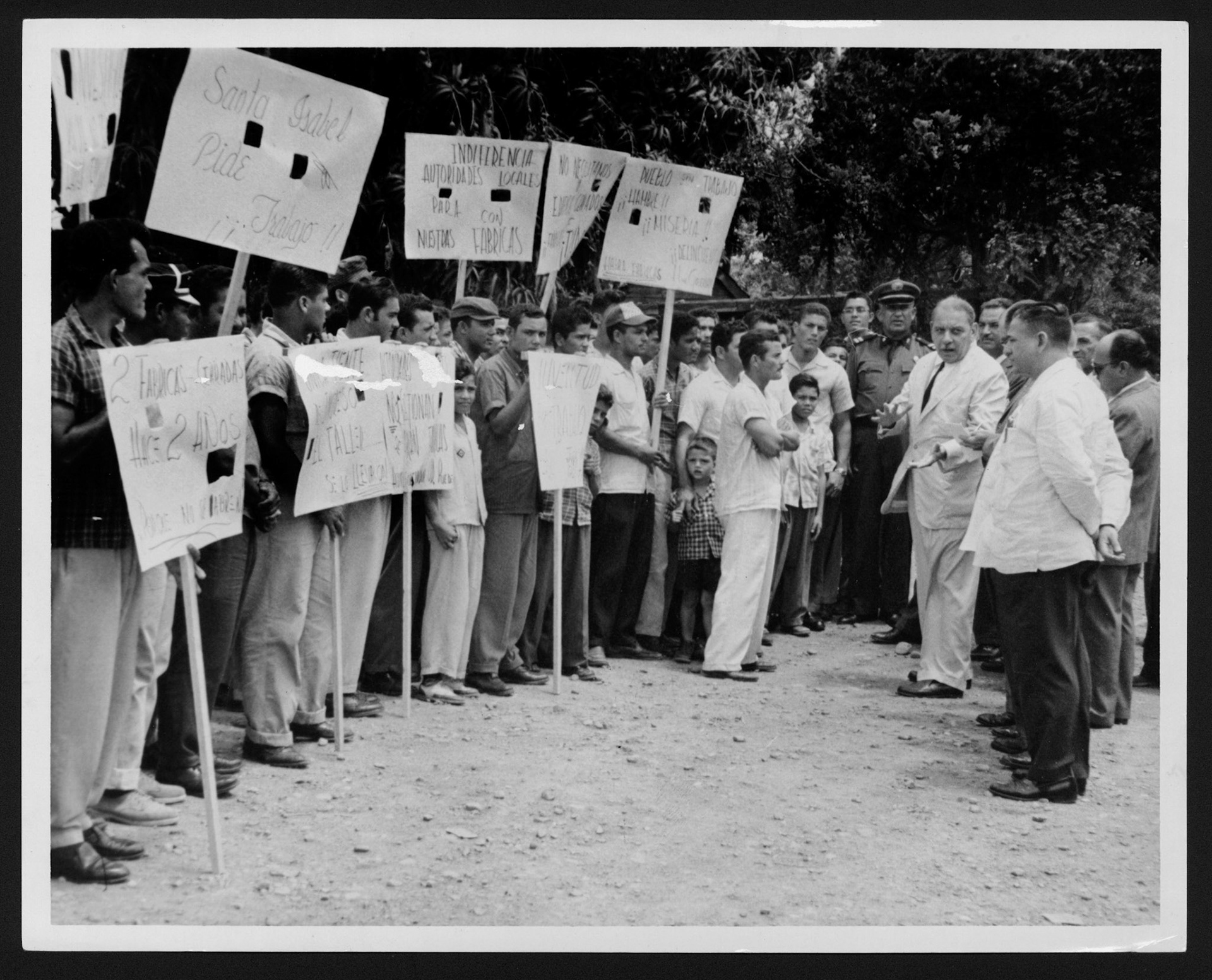 LUIS MUÑOZ MARÍN ATENDIENDO RECLAMOS DE UN GRUPO DE OBREROS EN SANTA ISABEL.ABRIL 13, 1958