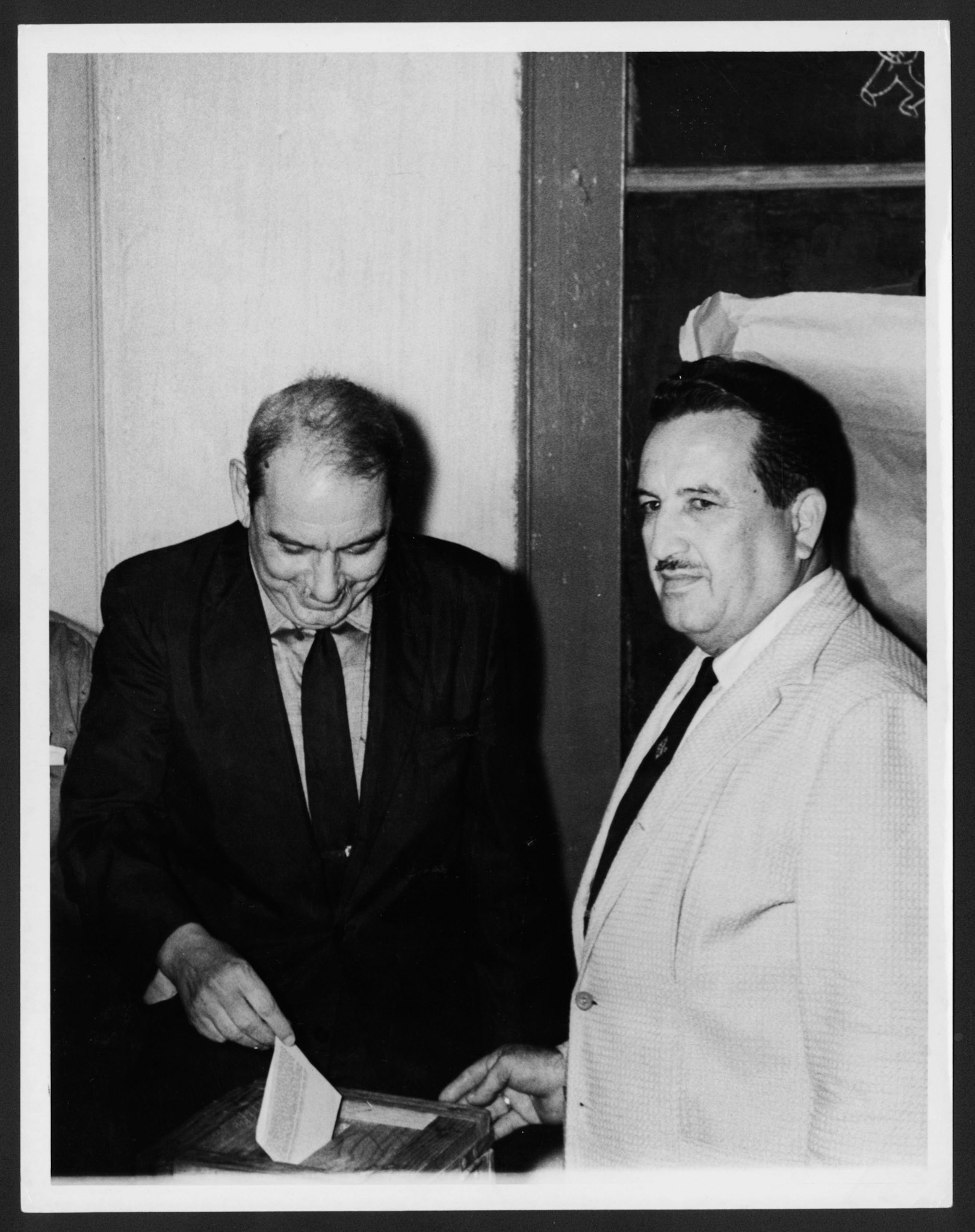 GOBERNADOR LUIS MUÑOZ MARÍN, JUNTO A UN CABALLERO, DEPOSITANDO SU VOTO EN LA URNA ELECTORAL EN REFERÉNDUM DE 1961.OCTUBRE 12, 1961