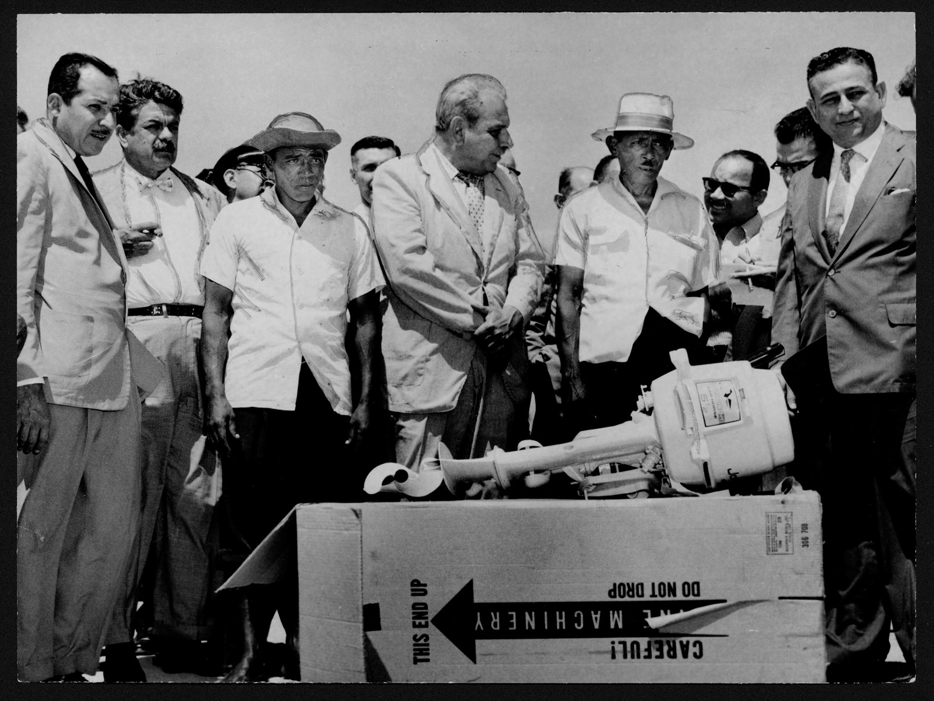 Gobernador Muñoz Marín junto a oficiales de gobierno en entrega de motor fuera de borda a pescadores de Las Croabas, Fajardo.Febreo 27, 1959