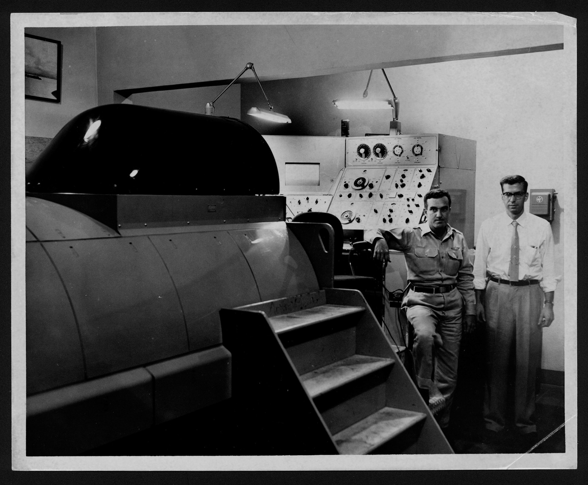 [Coronel Nido y Donald E. Small posando junto a simulador de vuelo.Isla Grande, San Juan.Agosto 15, 1955