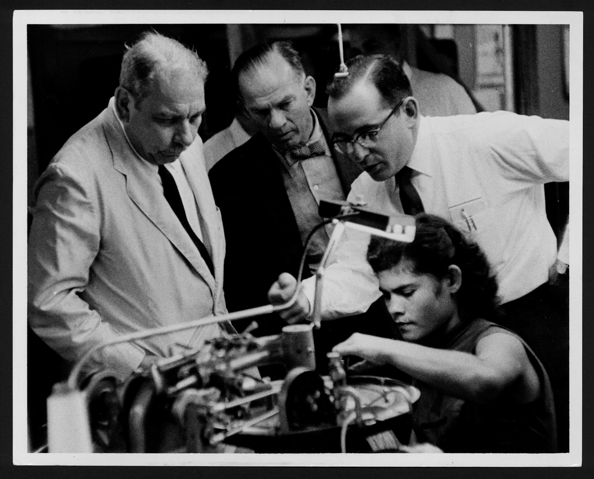 LUIS MUÑOZ MARÍN Y EL SENADOR J.W. FULBRIGHT OBSERVANDO EL PROCESO DE ELABORACIÓN DE MEDIAS EN UNA FÁBRICA DE CAYEY.ABRIL 11, 1958