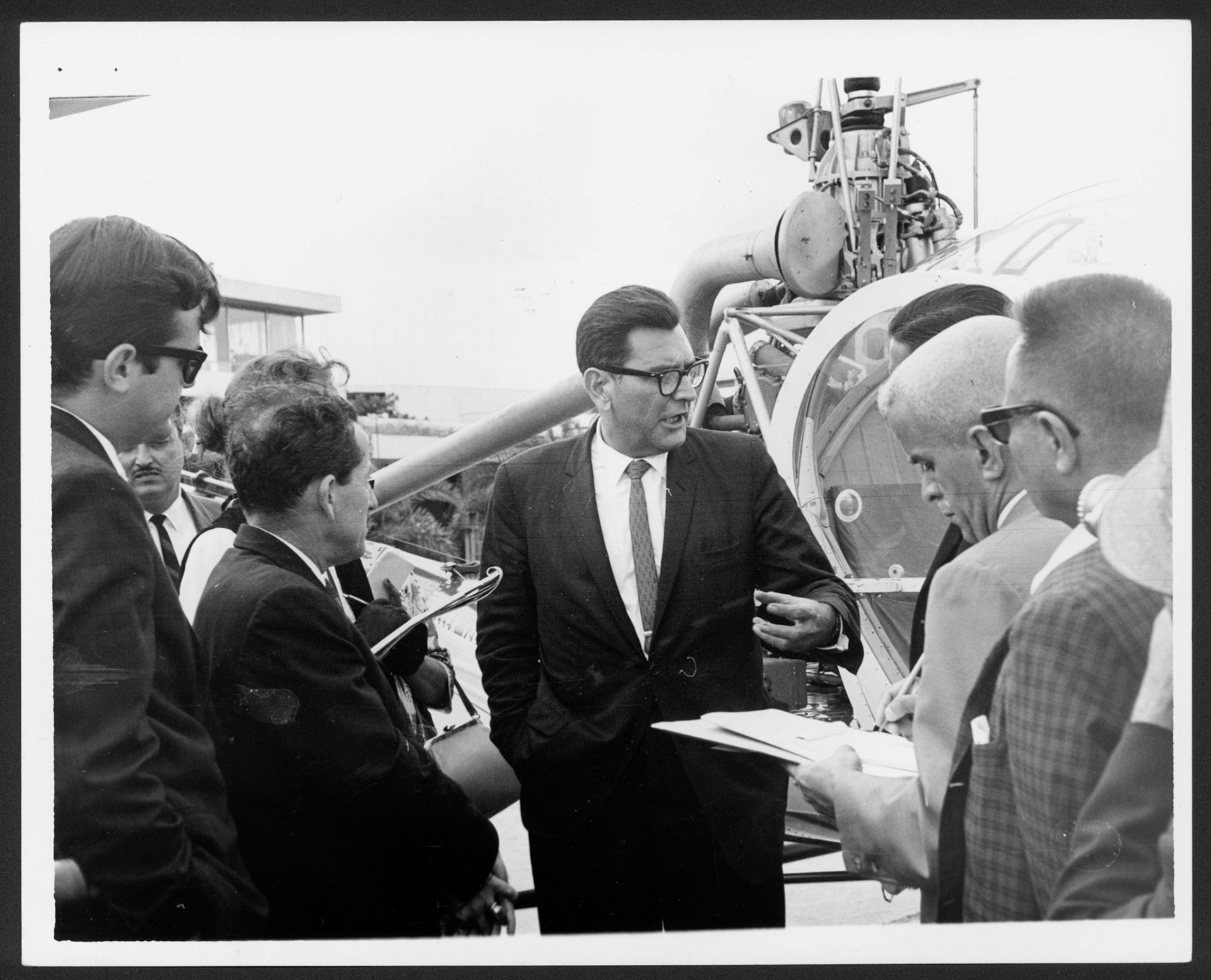 Sánchez Vilella, candidato a la gobernación, hablándole a periodistas al lado de un helicóptero.Octubre 1964