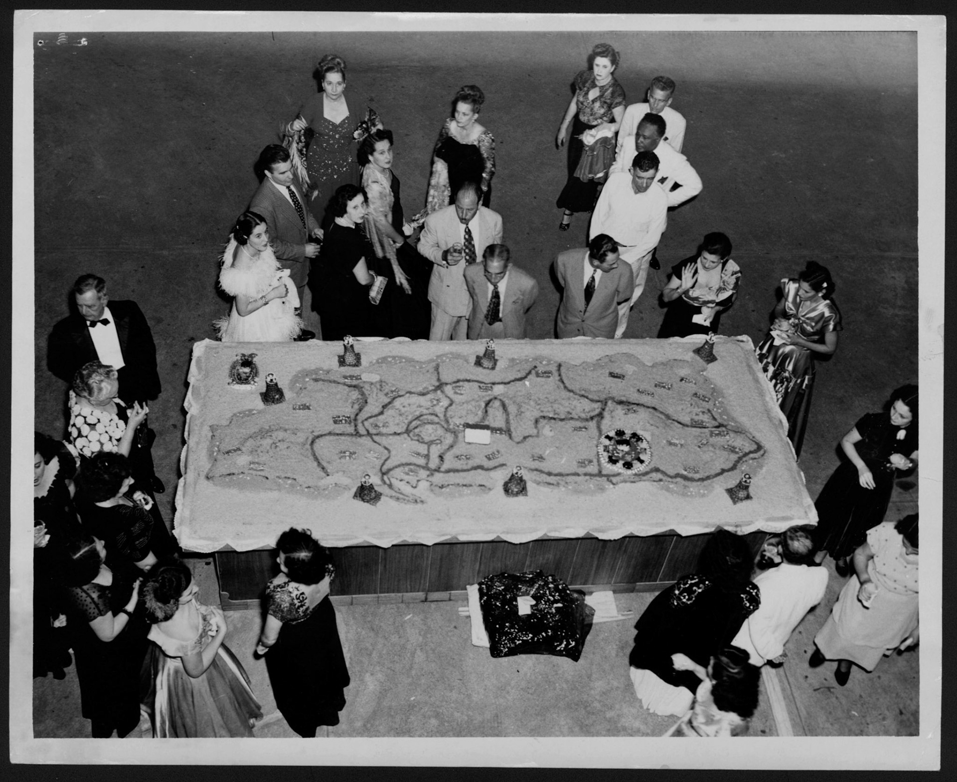 Invitados a la recepción en La Fortaleza observando un gigantesco bizcocho.Enero 2, 1949