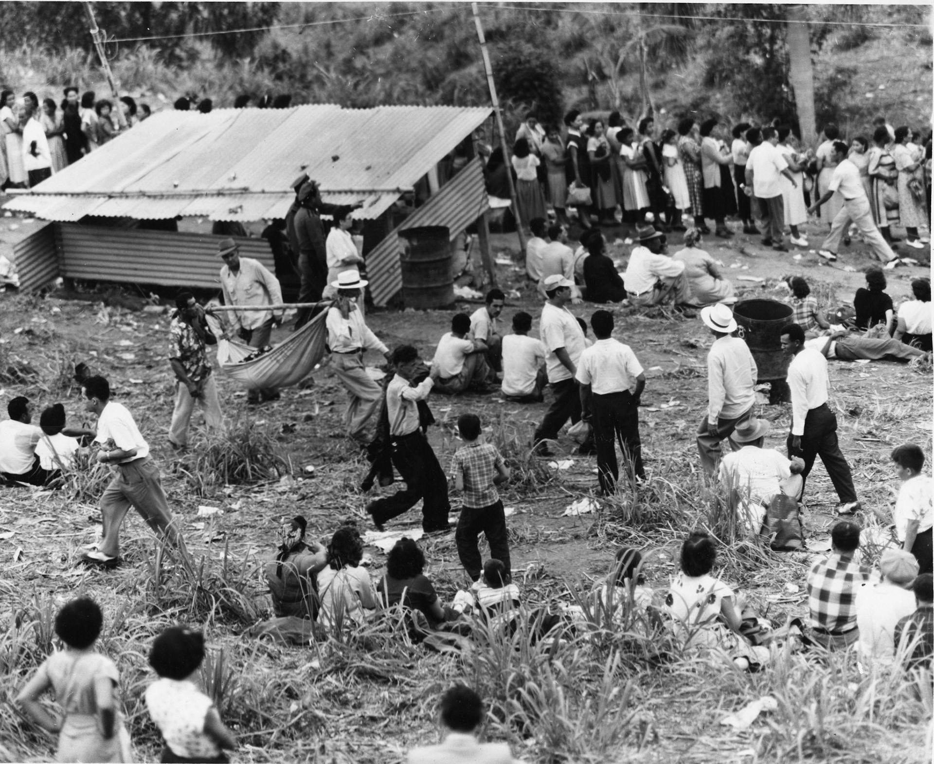 Llevan a mujer cargada en hamaca hacia el pozo.Barrio Rincón, Sabana Grande.1953