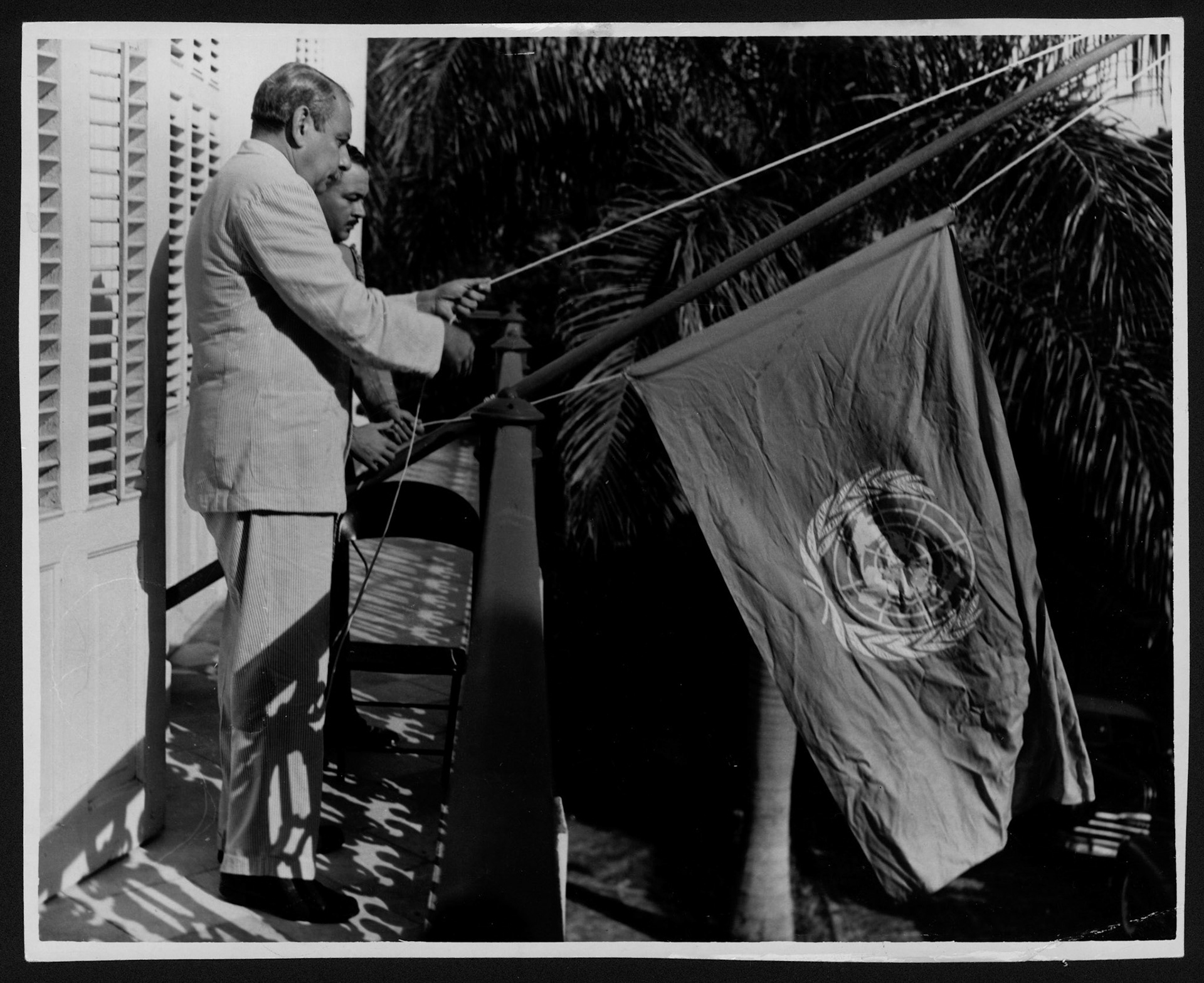 GOBERNADOR LUIS MUÑOZ MARÍN Y ALBERTO ARRILLAGA IZANDO BANDERA ONU EN SU DÍA, EN BALCÓN DE LA FORTALEZA.OCTUBRE 25, 1951