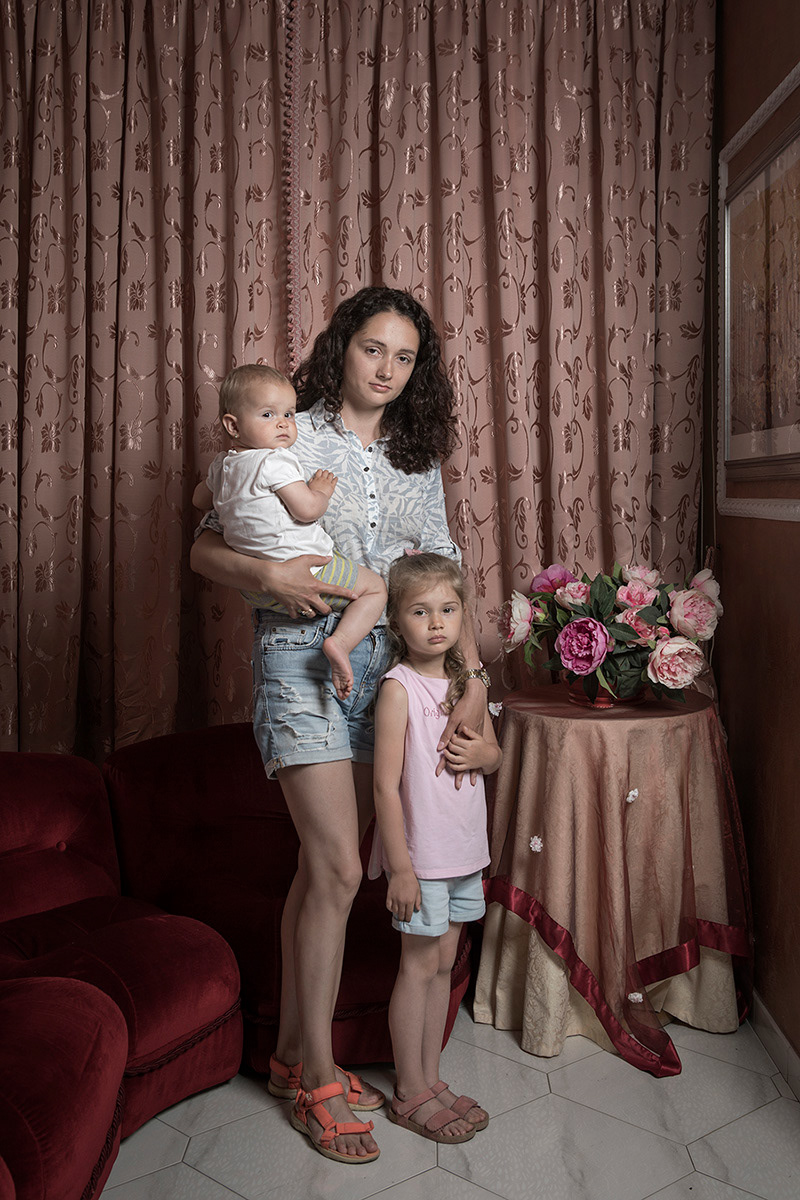 iuggi (FR), Italy, May 18, 2022. Alexandra Klimova portrayed with her daughters Adelina and Sara in the lobby of the Lorella hotel in Fiuggi, where she is staying with other Ukrainian refugees. Alexandra comes from Karchiv, where she worked in a travel agency. On February 25, after hearing her home shake due to a bombing, she and her husband decided to leave the city. Having a dog in the family, it was not possible to take refuge inside a bunker so they decided to move to the country house of their in-laws, a few kilometers from Karchiv. She stayed there for three weeks. On March 15, with the advancing Russian army, he decided to flee. Her husband took her and her daughters to Poltova in central Ukraine. There they said goodbye: her husband took refuge in Odessa while Alexandra and her daughters took a bus that would take them to the Czech Republic, where some of her husband's colleagues were waiting for her and where they arrived after three days and after waiting 12 hours for cross the border into Poland. After resting in a hotel for a few days, she took a plane ticket to Rome and from there she was taken to Fiuggi by the Civil Protection.
