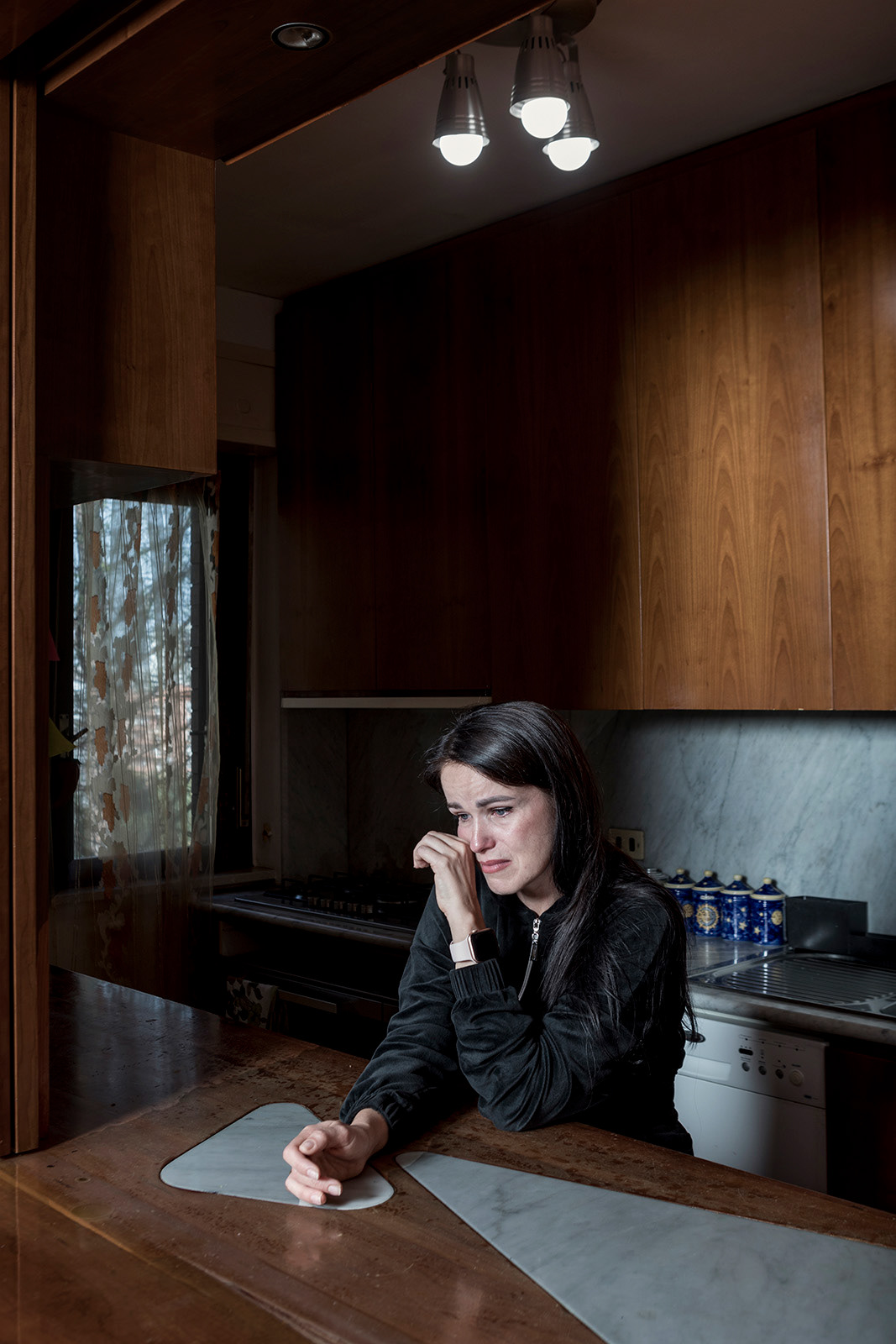 Rome (Italy), 27 october 2022. 36-year-old Oksana Andrushko portrayed at the apartment of the SAI Project "Aida Roma" in Rome Capital (ARCI Roma Aps and Be Free Soc. Coop.), Where she is staying with her two children aged 15 and 6. Oksana comes from Lviv, where she worked as a restaurant assistant manager, while her husband worked as a marble worker. Oksana's mother has lived in Rome for 22 years and Oksana and her family had already come to Italy several times, especially for the health care that her eldest son needs. Oksana, even before the war began, had already bought a plane ticket with departure on March 13 to have her son visited at an Italian hospital. Following the outbreak of the war, fearing that she would not be able to travel by plane due to the closure of Ukrainian airspace, she took the first available bus and headed for the Chop border, on the border with Hungary. On March 4, after three days in line at the border, he arrives in Italy. The first week she and the children were guests of the house where the mother works, where 12 lived in an apartment. Later she was transferred to a hotel and later to a reception center in Pisiniano, in the province of Rome. Due to the great distance from the hospital that his son is treating, he requested and obtained a transfer to Rome. 3 weeks ago the son underwent a preliminary surgery, pending the definitive one which will take place in a few months. Before the surgery, Oksana sent all the medical documents to Ukraine and managed to get her husband an exit permit, as the parent of a handicapped child. Now her husband also lives in Rome, temporarily in a hotel, and occasionally does some painting work.  So far, over 100,000 people have fled Ukraine since the conflict began and arrived in Italy, mostly women and minors. To ensure their assistance, a system has been defined that provides for different forms of support that are complementary to each other. In addition to placement with Italian and Ukrainian families residing in Italy at the ordinary network of CAS (Extraordinary Reception Centers) and the SAI (Reception and Integration System), a widespread reception system has been introduced which assigns a key role to Third sector, to voluntary associations and religious bodies. The association or body must guarantee, in addition to food and accommodation, help with school and work integration, legal guidance, linguistic literacy and psycho-socio-health assistance.