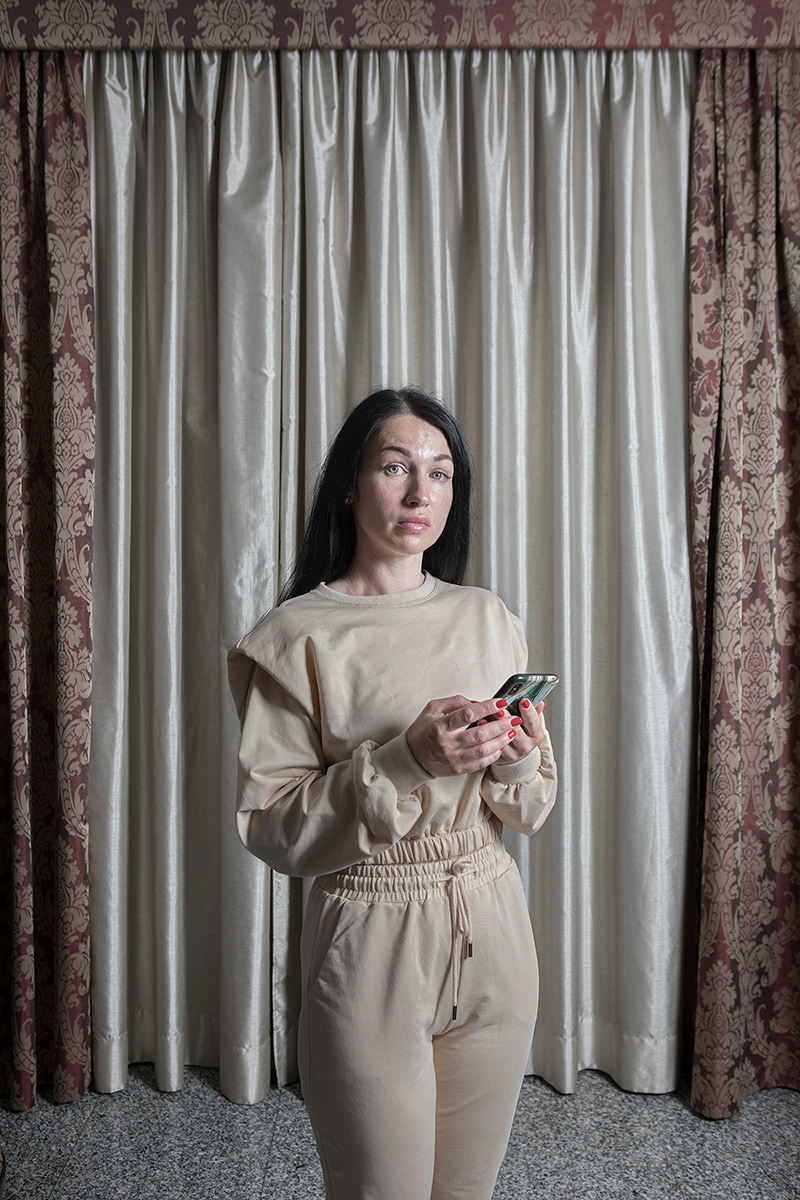 Frosinone, Italy – May 26, 2022. Nadiya Valiavskayia, 37, is staying at the Astor Hotel in Frosinone with other Ukrainian refugees. She comes from Mykolaiv and fled with her 18-year-old daughter, Katerina. Nadiya has a degree in psychology and worked as a manager for a jewelry chain, earning a good income. She also sold Italian clothing online and lived comfortably before the war. On February 24, 2022, she woke to the sound of explosions so strong that car alarms went off. She grabbed documents and essentials, woke her daughter, and took refuge in a friend’s building equipped with a bunker. For a week she stayed there, returning home only briefly to feed her dog and cat. Despite fear and uncertainty, she decided to leave on March 15. While she was packing, the power went out and she finished getting ready by phone light. A contact offered her a paid ride to Odesa, and from there she reached the Moldovan border, where she saw crowds of women and children fleeing. She crossed at Palanca by coach, then continued by bus to Chișinău, where she delivered forgotten documents to a friend. She shared a rented room for three days with three families, but when it was no longer possible to stay, she asked a woman she met on the street for help. The woman hosted her for a few days, and Nadiya showed gratitude by shopping and cleaning. On the fourth day, she was driven to the bus station and bought a ticket to Italy. After a 36-hour journey she arrived in Rome, where an acquaintance brought her to Frosinone. Once she completed the paperwork and received her residence permit, Civil Protection assigned her a place at the Astor Hotel, where she now lives.