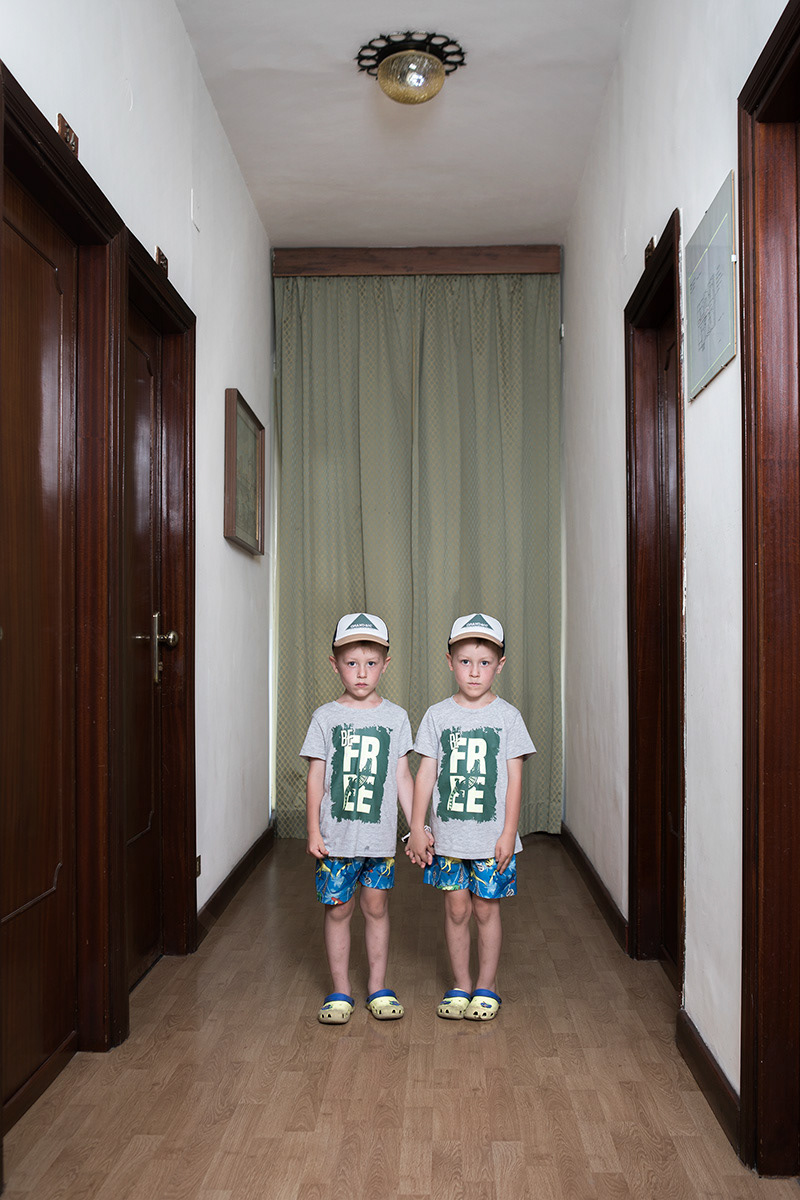 Fiuggi (FR), Italy – June 8, 2022. Zakhar and Nazar Piskun, 5-year-old twins from Sumy, are staying at the Holiday Hotel in Fiuggi with their mother, Yuliia, an elementary school teacher who still teaches online. The family lived in the countryside near the Russian border. On the morning of February 24, they woke to news of bombings and saw the sky turning red in the direction of the border. They packed quickly and fled with the twins’ great-grandmother, using all three family cars. On the way, a rocket landed beside the car carrying Yuliia’s father, but the family eventually reached the school where she worked and sheltered there for three days. When rockets began hitting a nearby military academy, they decided to return home, traveling in separate cars so the children would not be together if something happened. On the road they saw Russian military vehicles and heard gunfire, but managed to get back safely. Days later, a Russian tank stopped right outside their house, forcing the family to lie on the floor until it moved away. Soon after, Yuliia’s mother unexpectedly returned from abroad and reached Sumy via Poland and secondary roads, just as Russian forces withdrew. When a humanitarian corridor opened, the family agreed that Yuliia and the twins should leave Ukraine. Her husband drove them to Ternopil, then returned home while Yuliia and the children crossed into Poland. After a month hosted by a Polish family, she chose to continue to Italy on a friend’s advice. The Red Cross welcomed them at Fiumicino airport and sent them to Fiuggi, where they have been living since May 6.