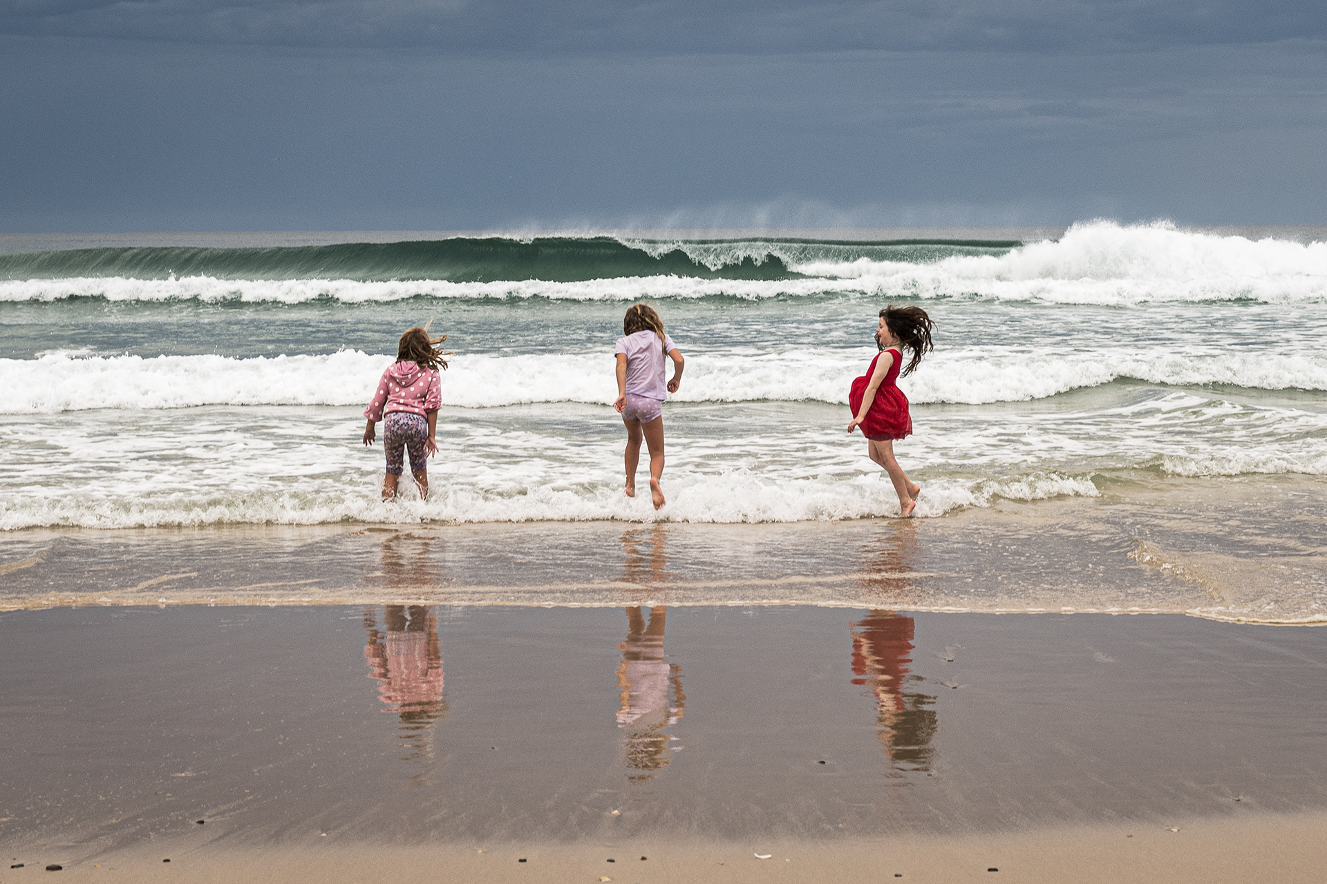 three friends jumping waves
