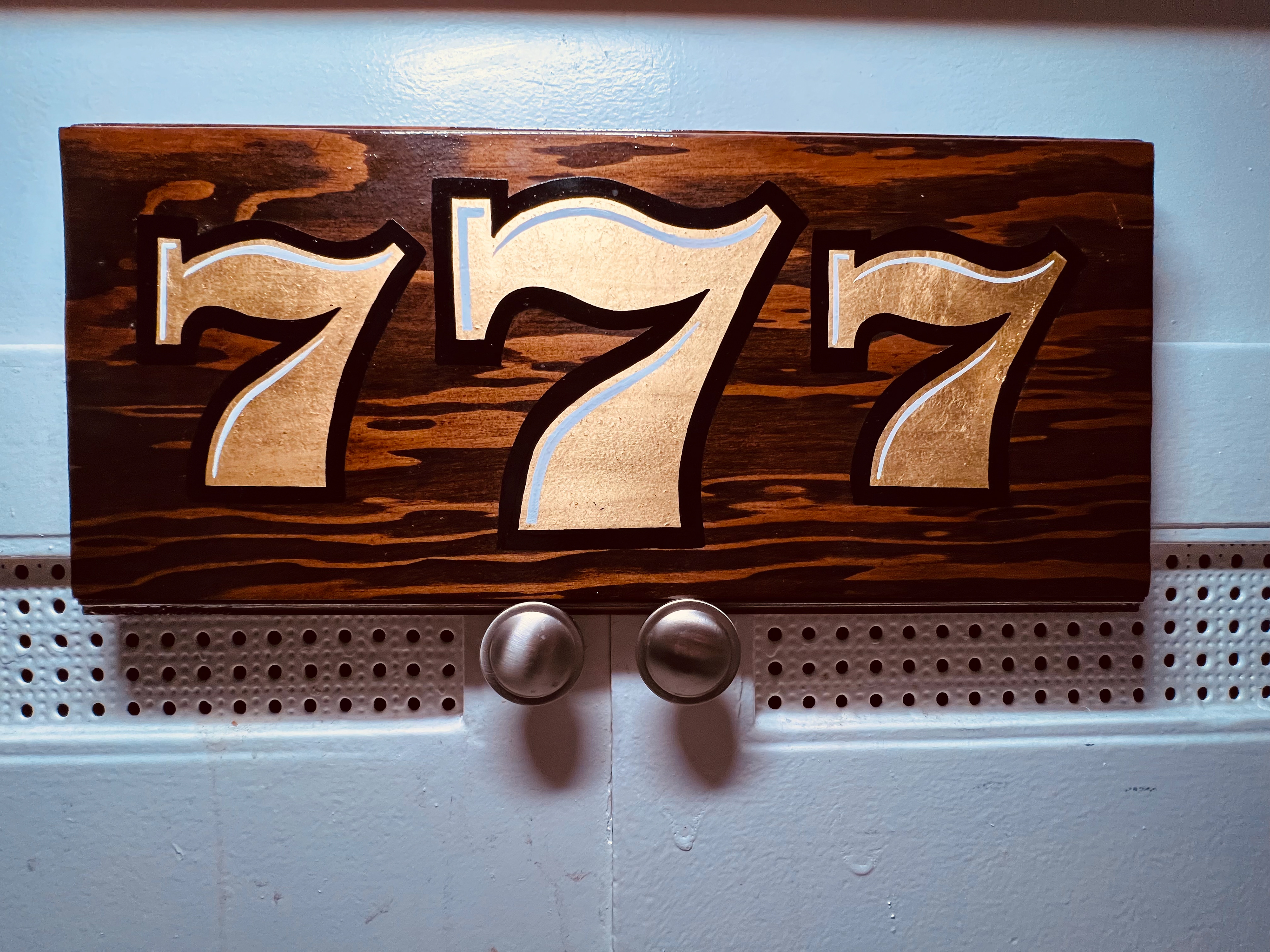 Gold leaf and enamel on stained wood