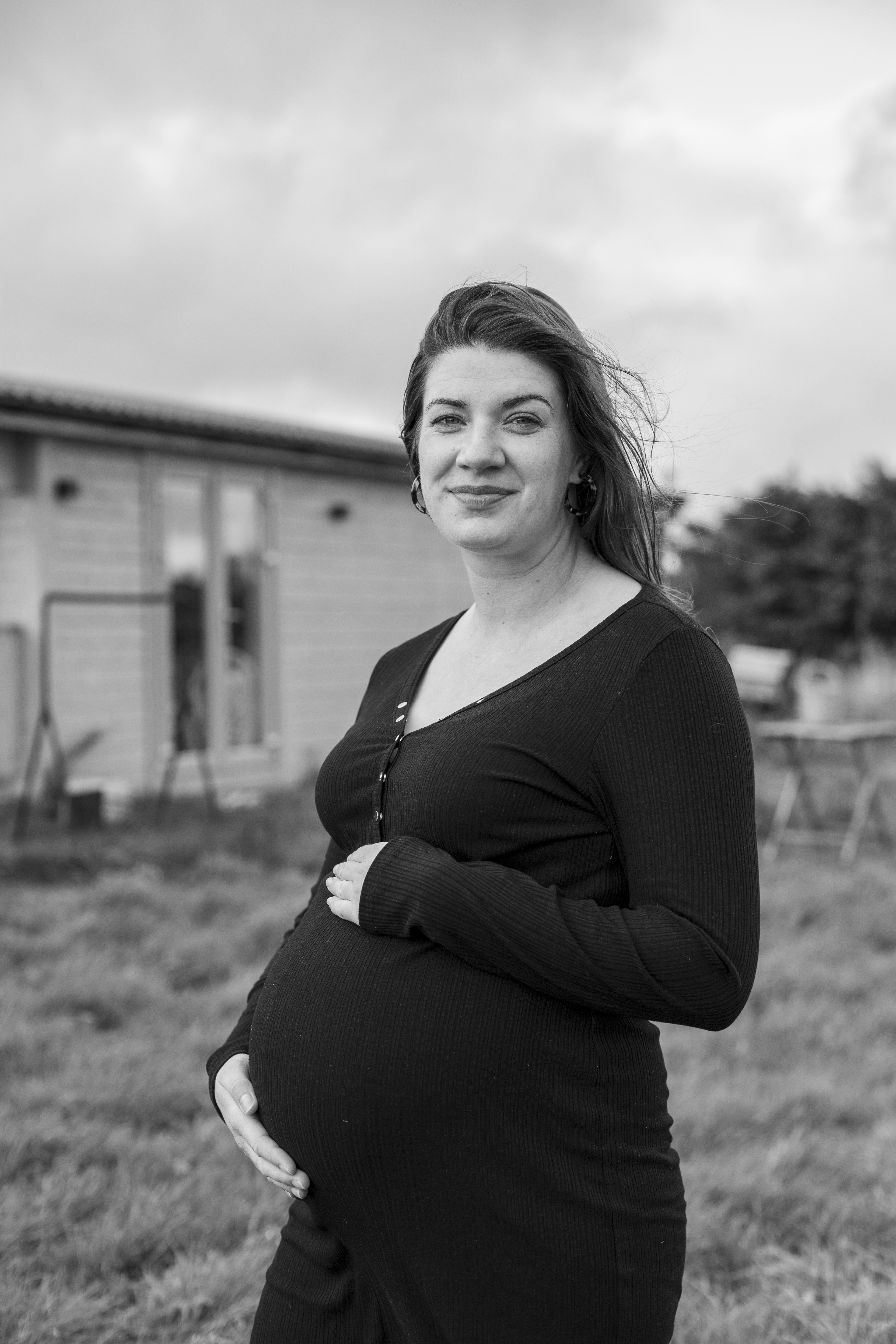 Pregnant woman holding her belly B&W portrait 