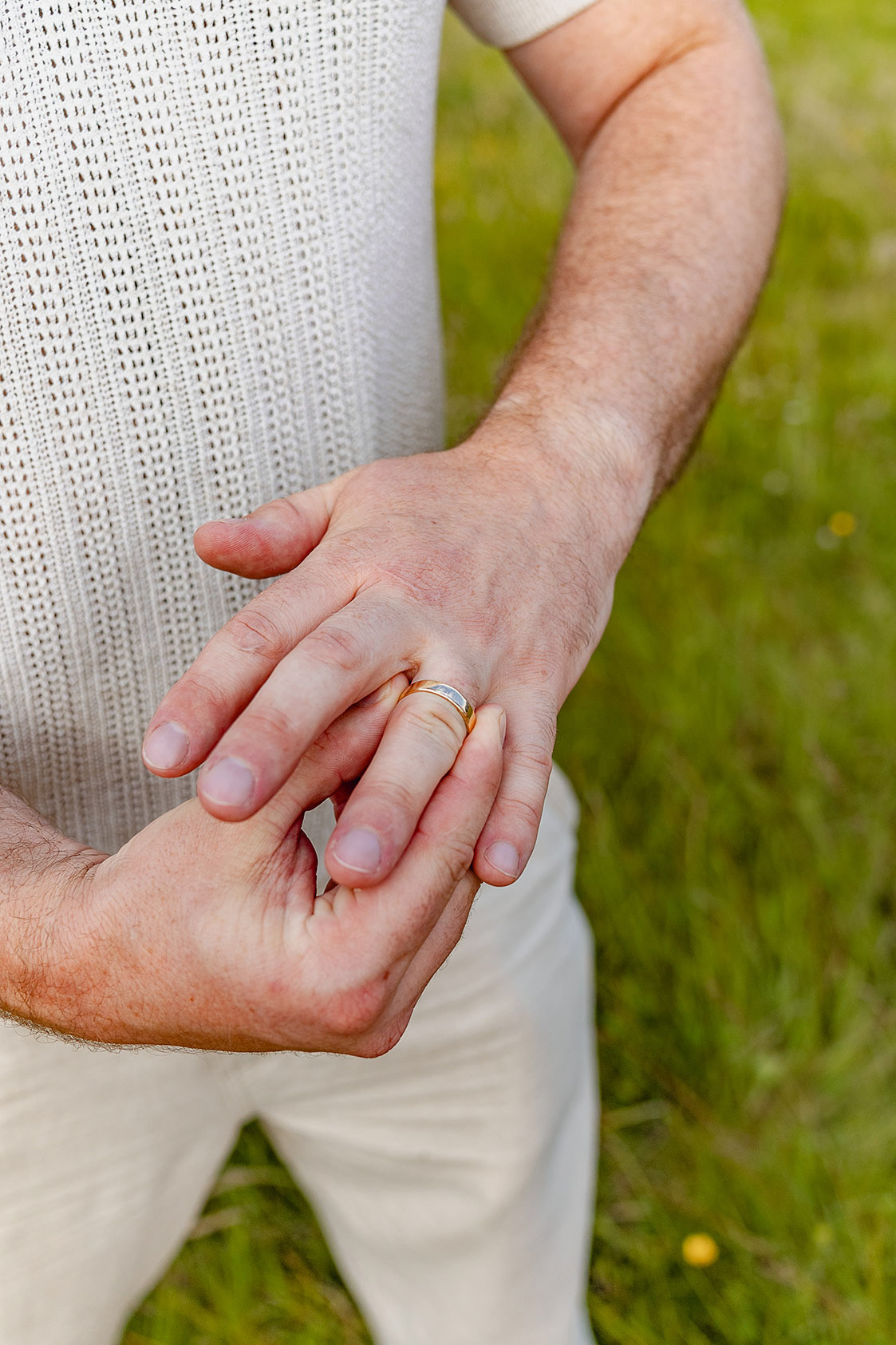 Man's hands with one touching his wedding ring