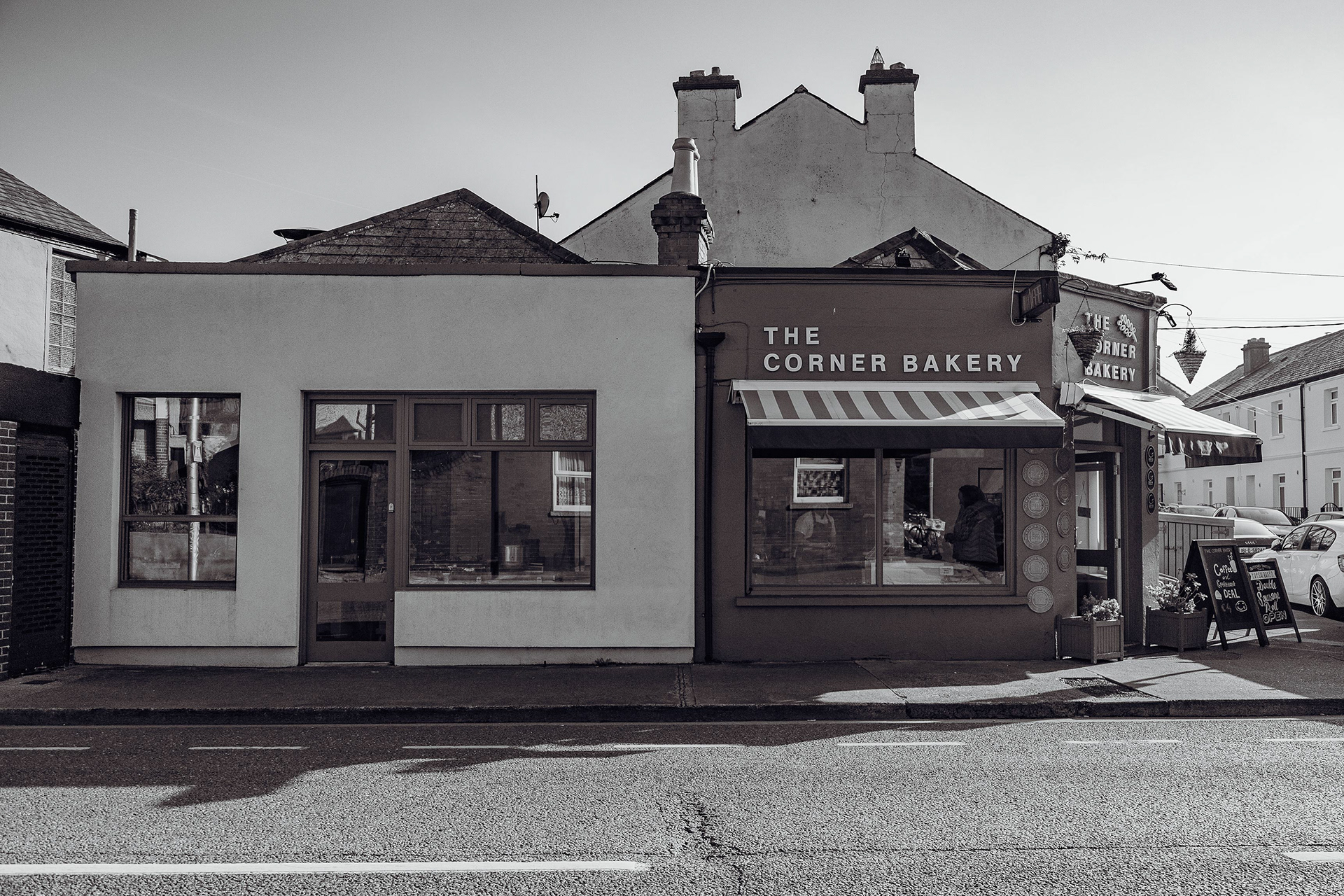 Corner Bakery exterior shot in black & white on a sunny day