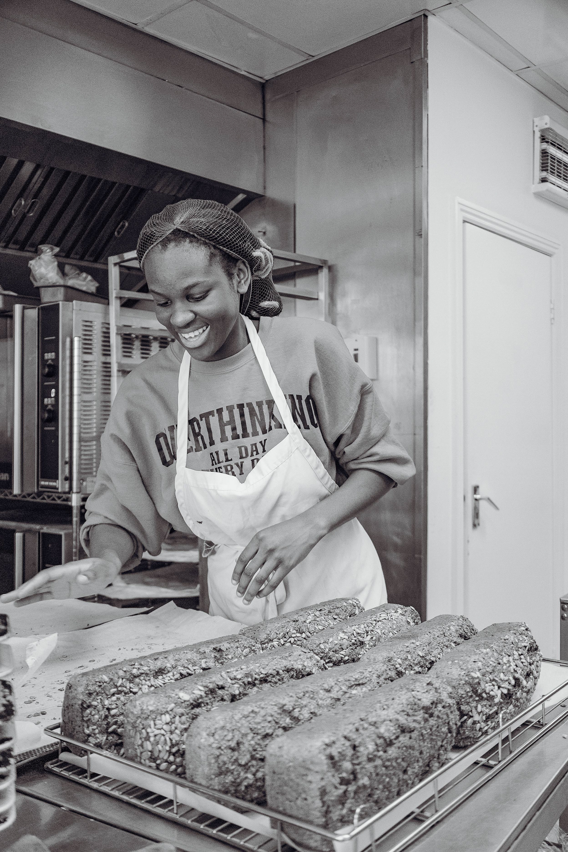 Baker looking at freshly baked bread and smiling
