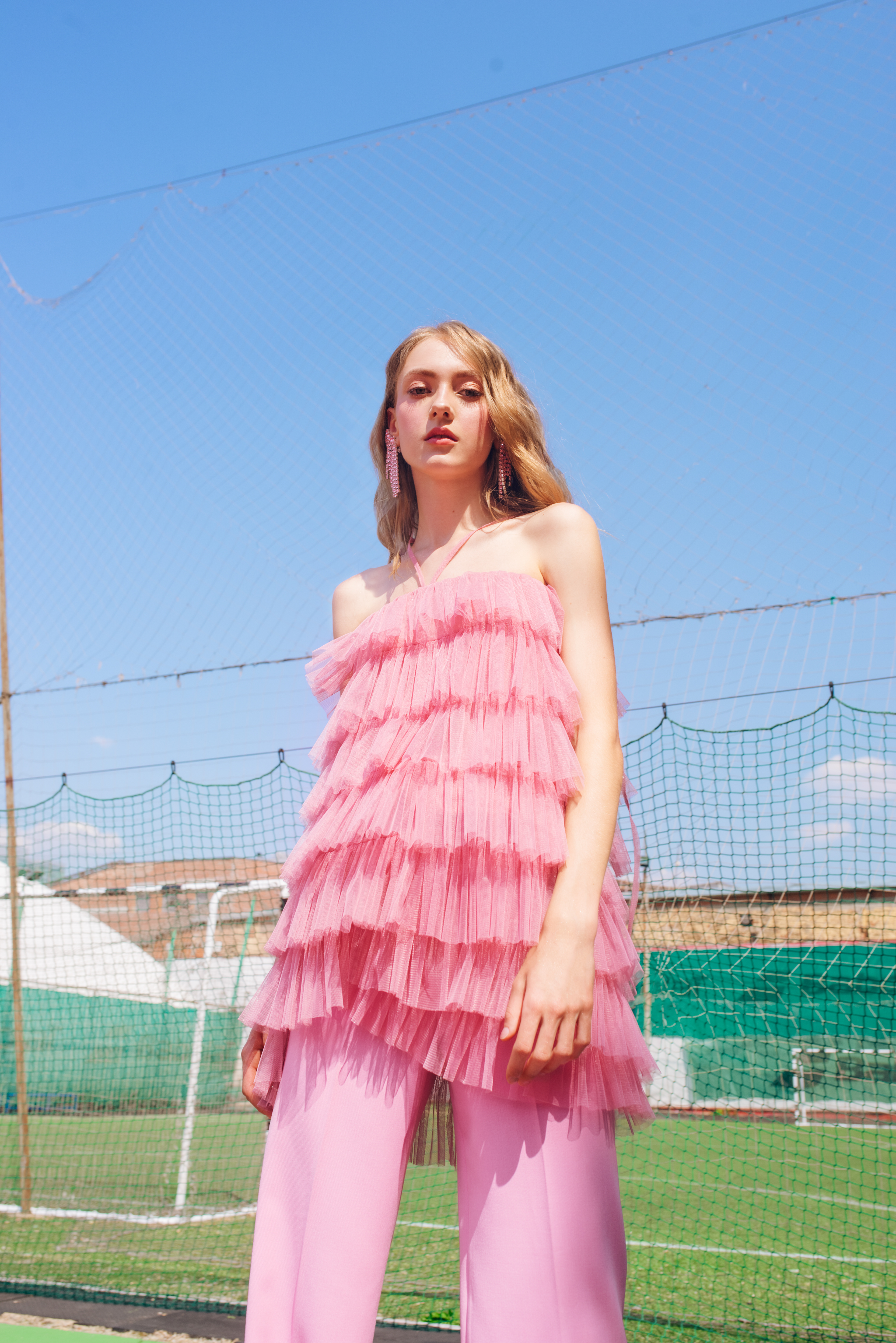 shot of a woman wearing a pink outfit in a football court