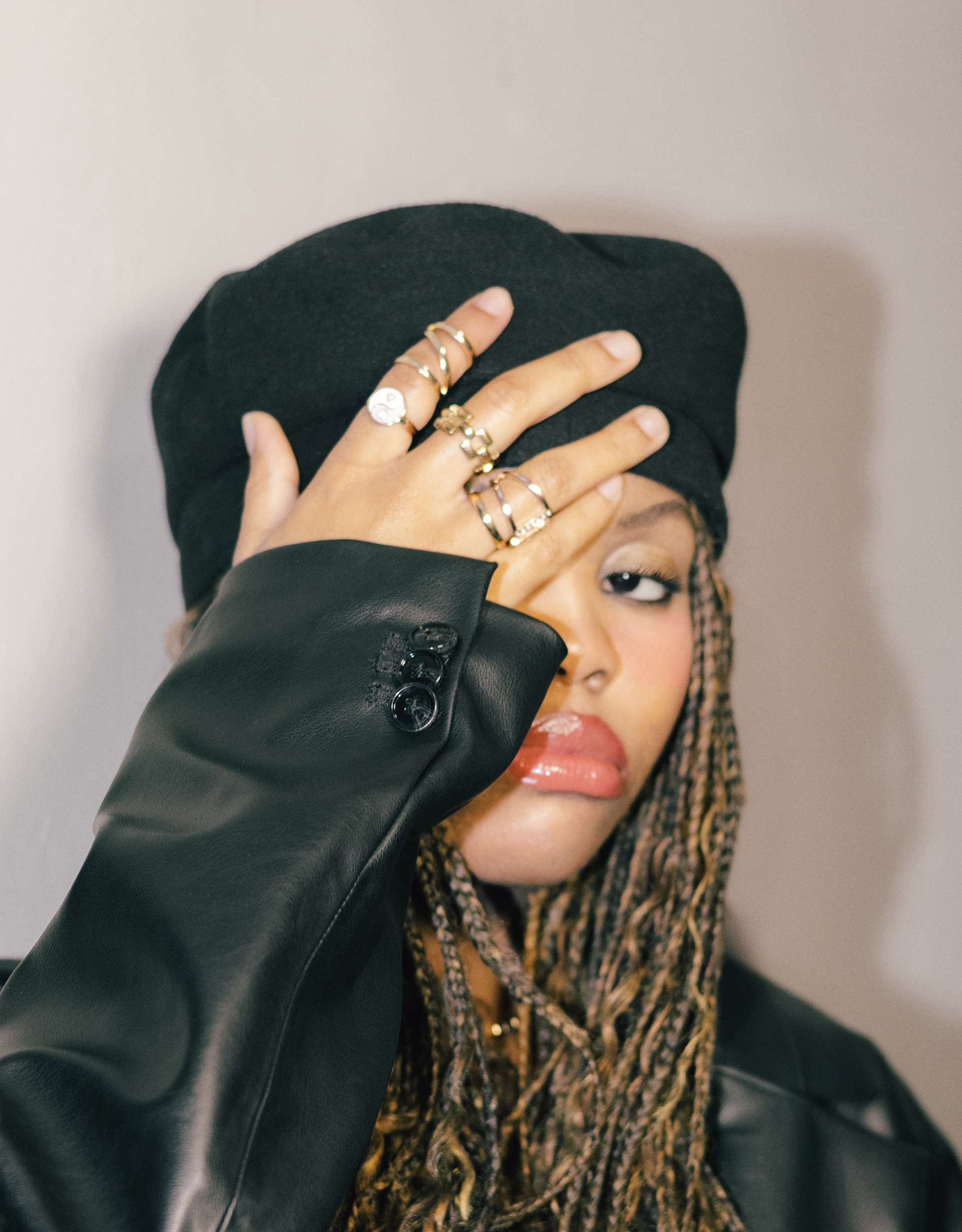 shot of a woman wearing a black beret, advertising gold jewelry 