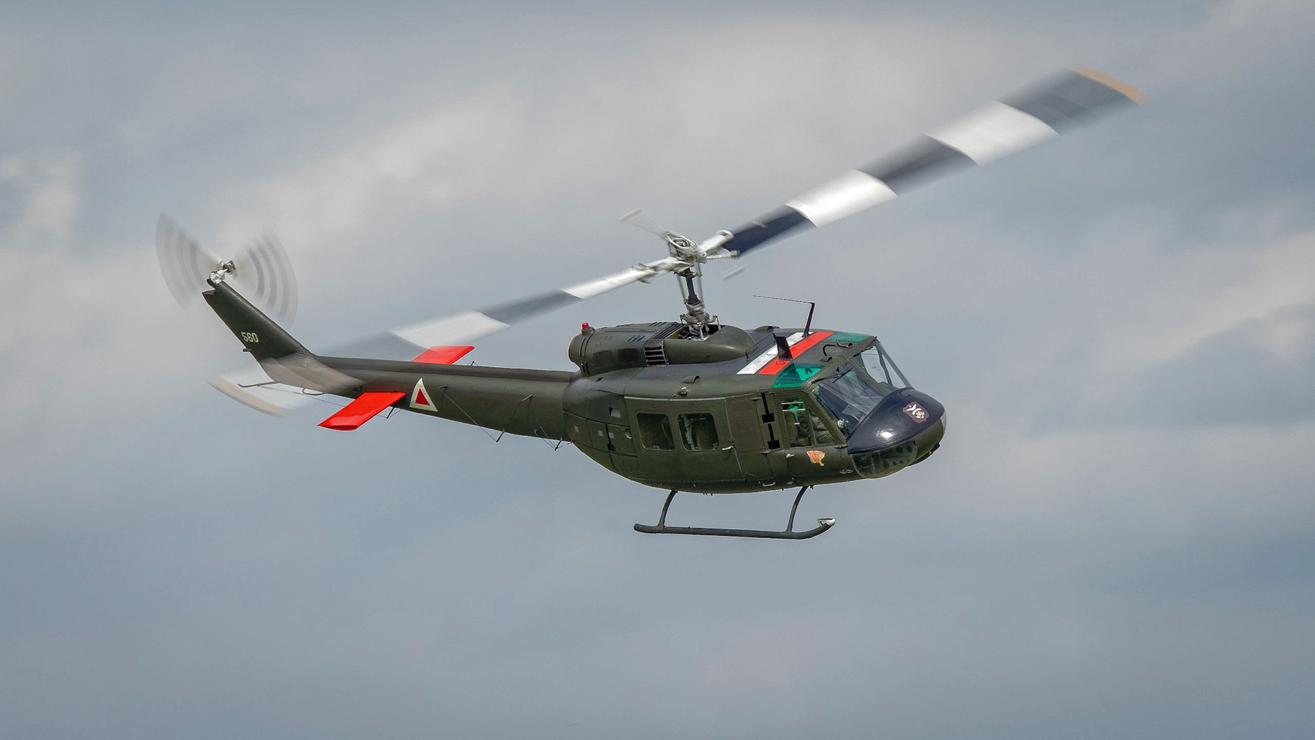 A vintage Huey helicopter in flight