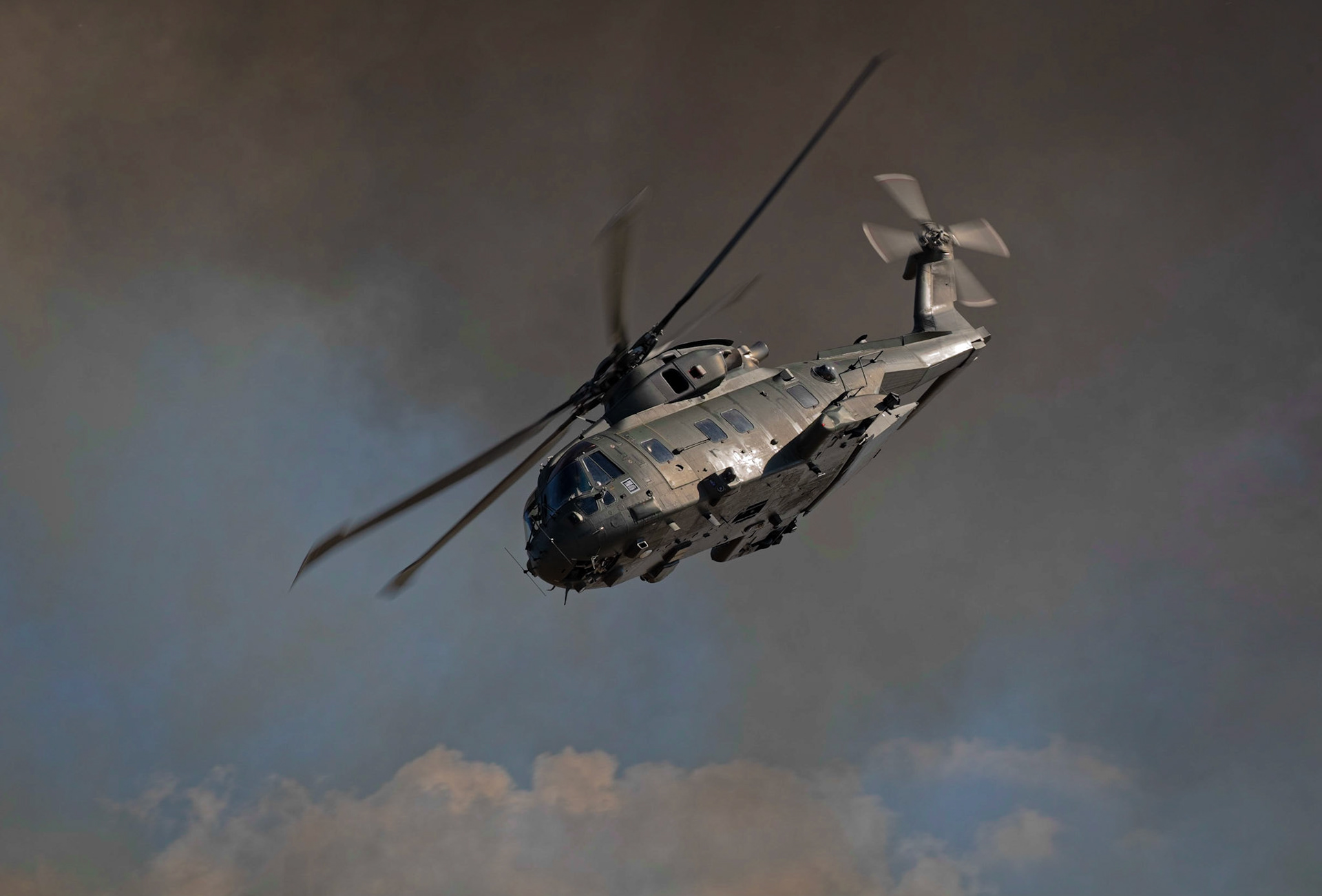 Royal Navy Merlin helicopter in smoke of battle