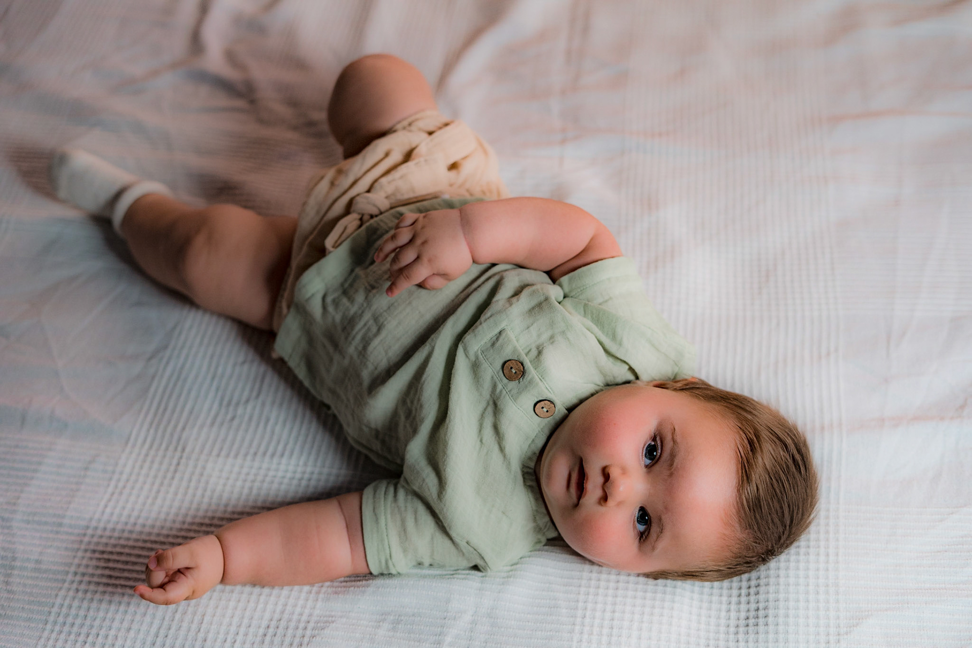 Sitting baby in vintage clothes for photo shoot