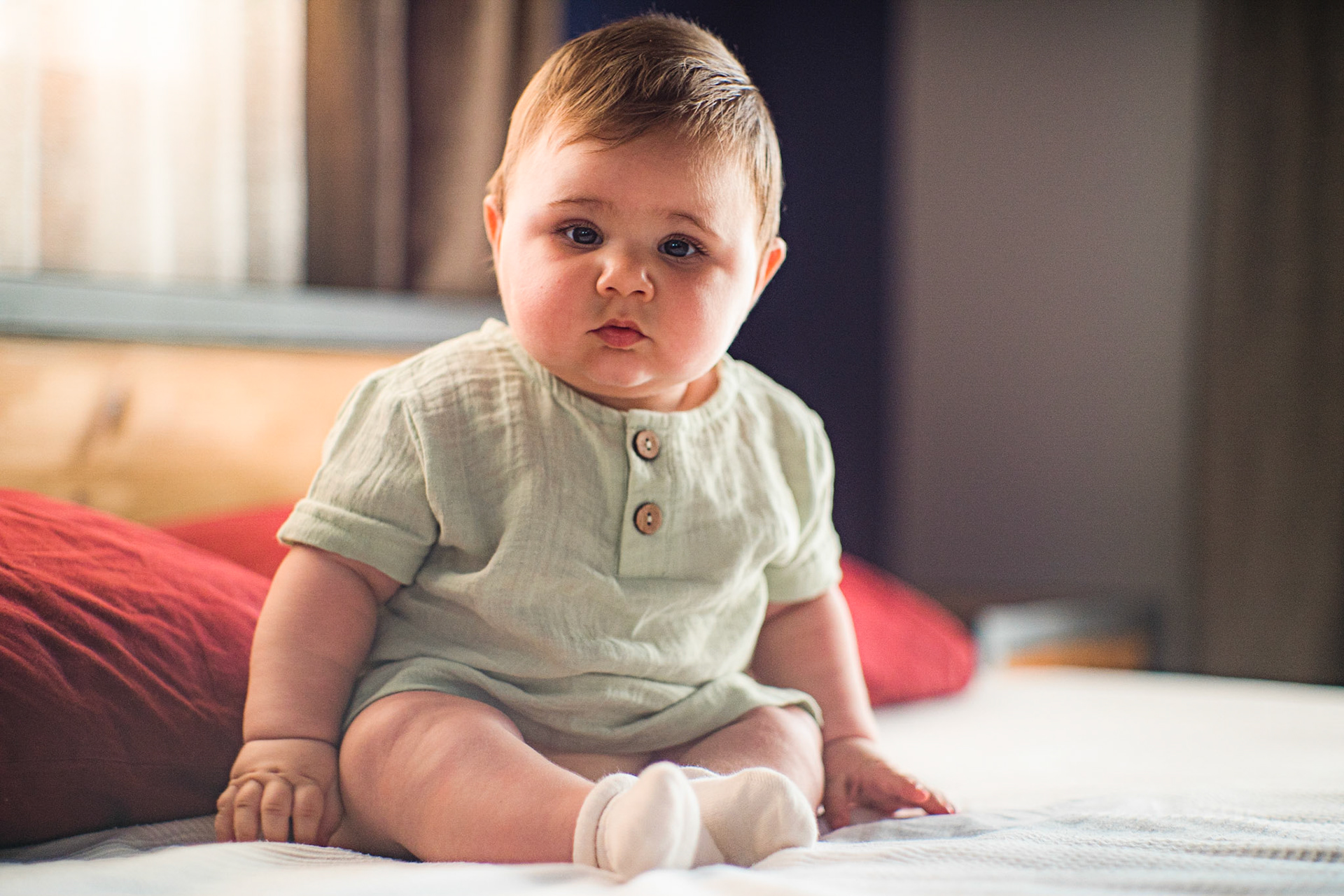 Sitting baby in vintage clothes for photo shoot