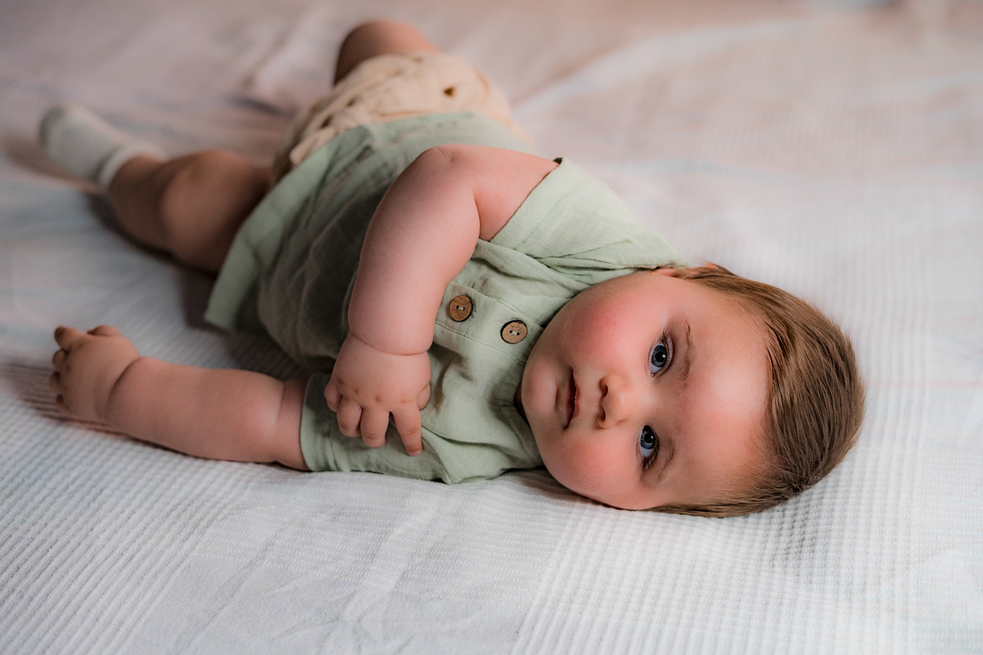 Sitting baby in vintage clothes for photo shoot