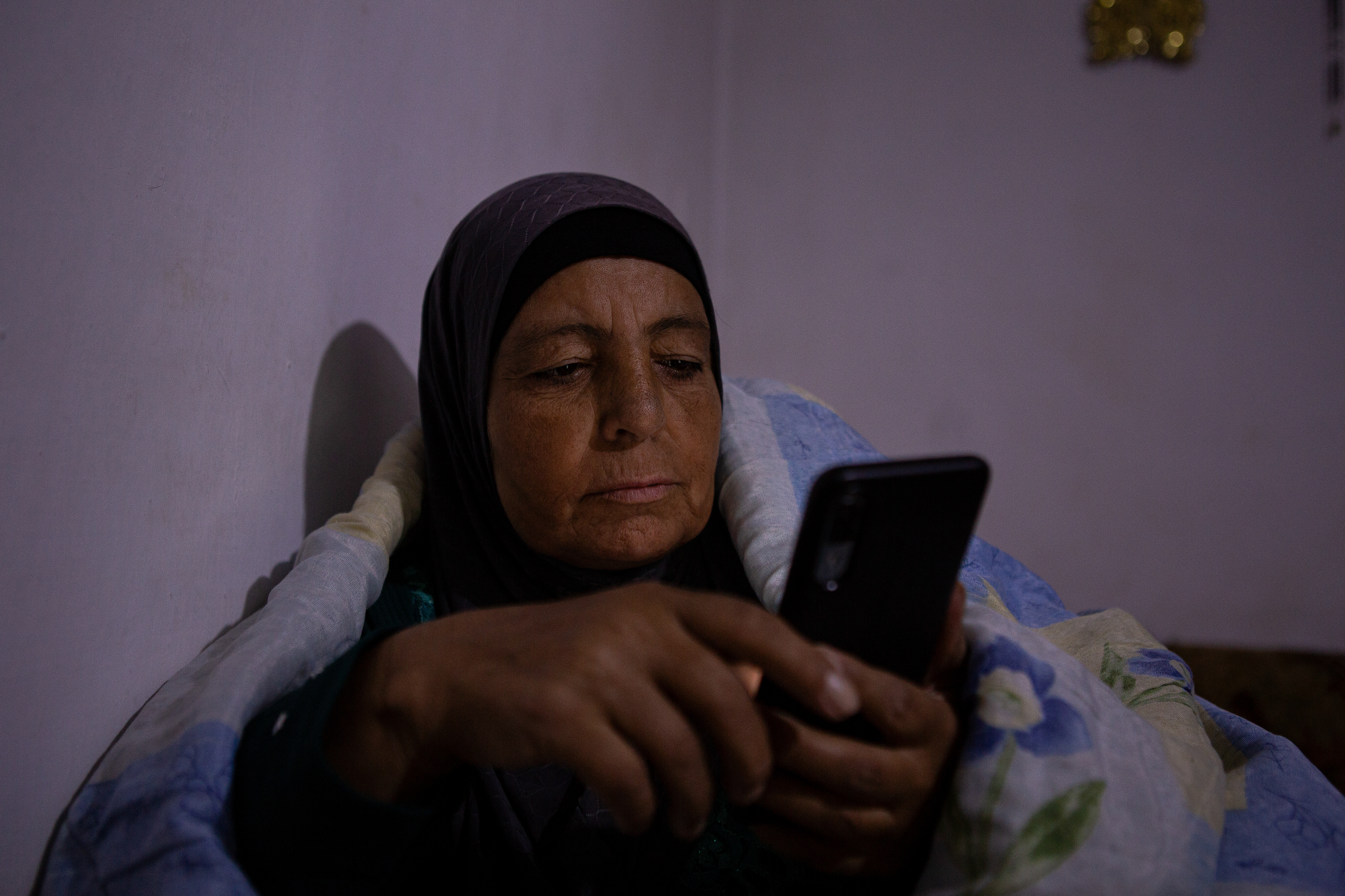 Fatma looks at the news from Syria on her phone after a day of working in the greenhouses. This has become a nightly ritual since the fall of Assad. “We’ll finish this season first,” she said. “We’ll harvest this crop and get it ready for sale. Only then, if Syria is safe, we will return.”