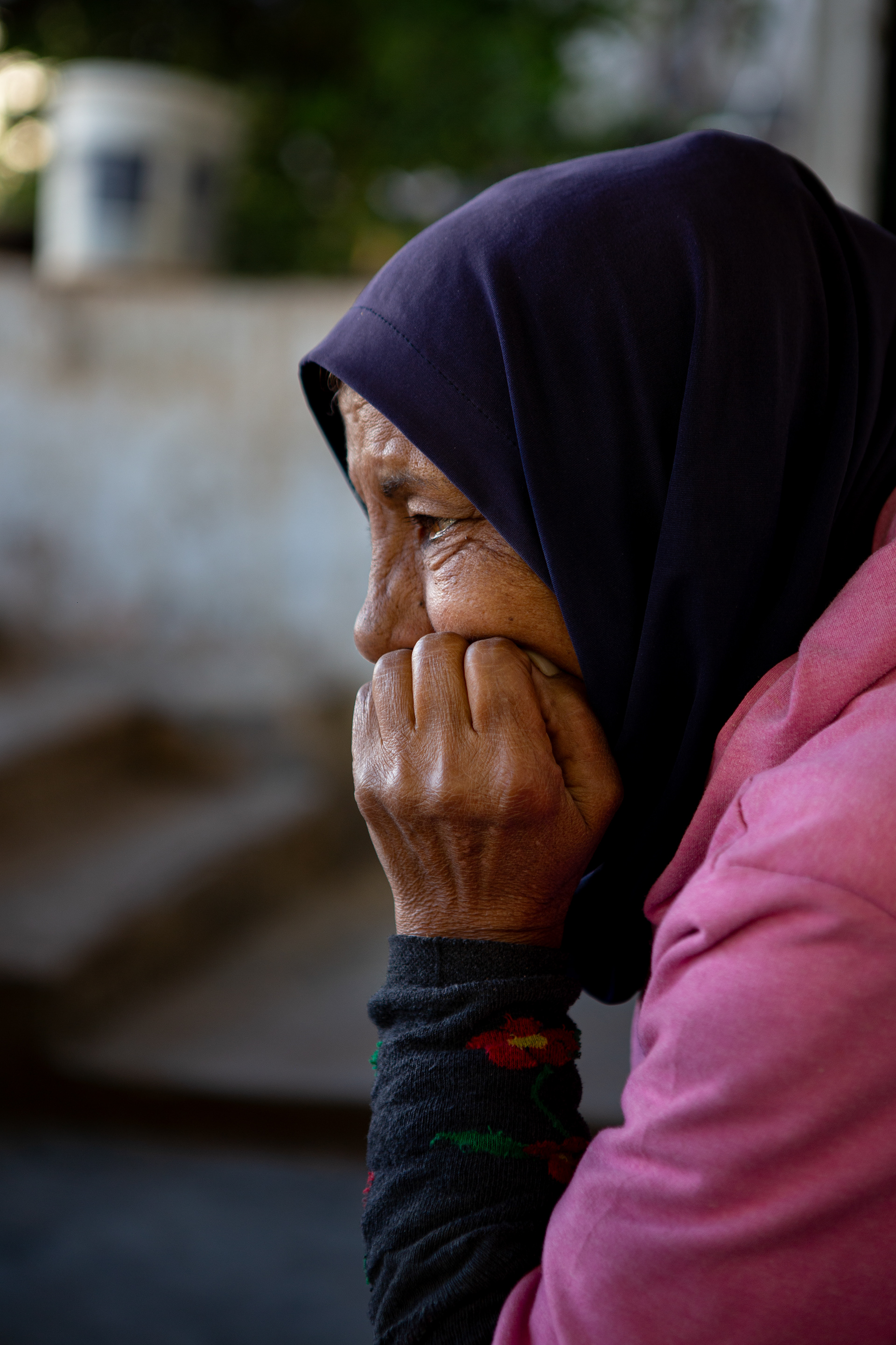 Munira*, 56, originally from Idlib, rests after a morning working in the greenhouse pruning and weeding.