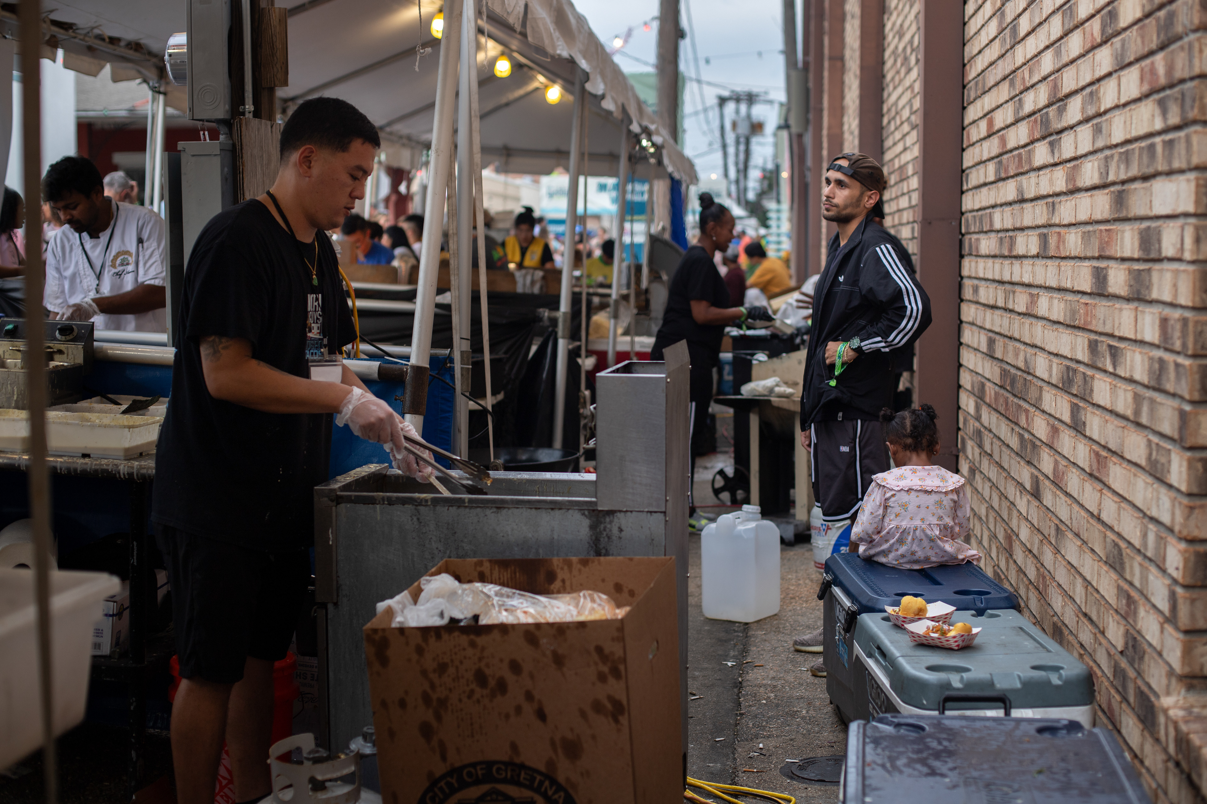Chefs work and rest behind the stalls in the Asian food section of Gretna festival on October 5th. The festival attracts thousands of people a year and comprises local food vendors, music acts, art, and cultural performances. They food served food from 11am to 10pm on this day.