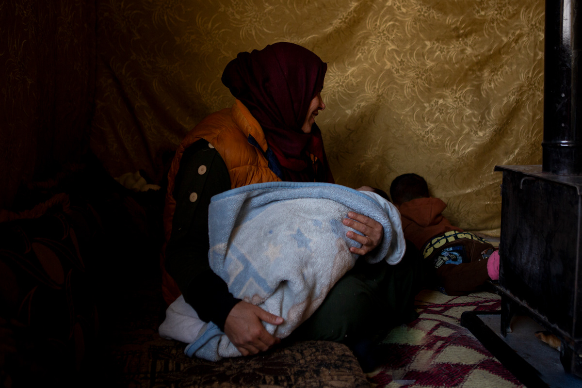 Nahla, 41, gently rocks her newborn son at her sister's home in the Bekaa Valley. Normally, she works on a cattle farm in the Mount Lebanon region, but she has traveled to Bekaa seeking medical assistance through UNHCR for her baby, who was born with a congenital condition affecting his urinary system. (12/19/2024)