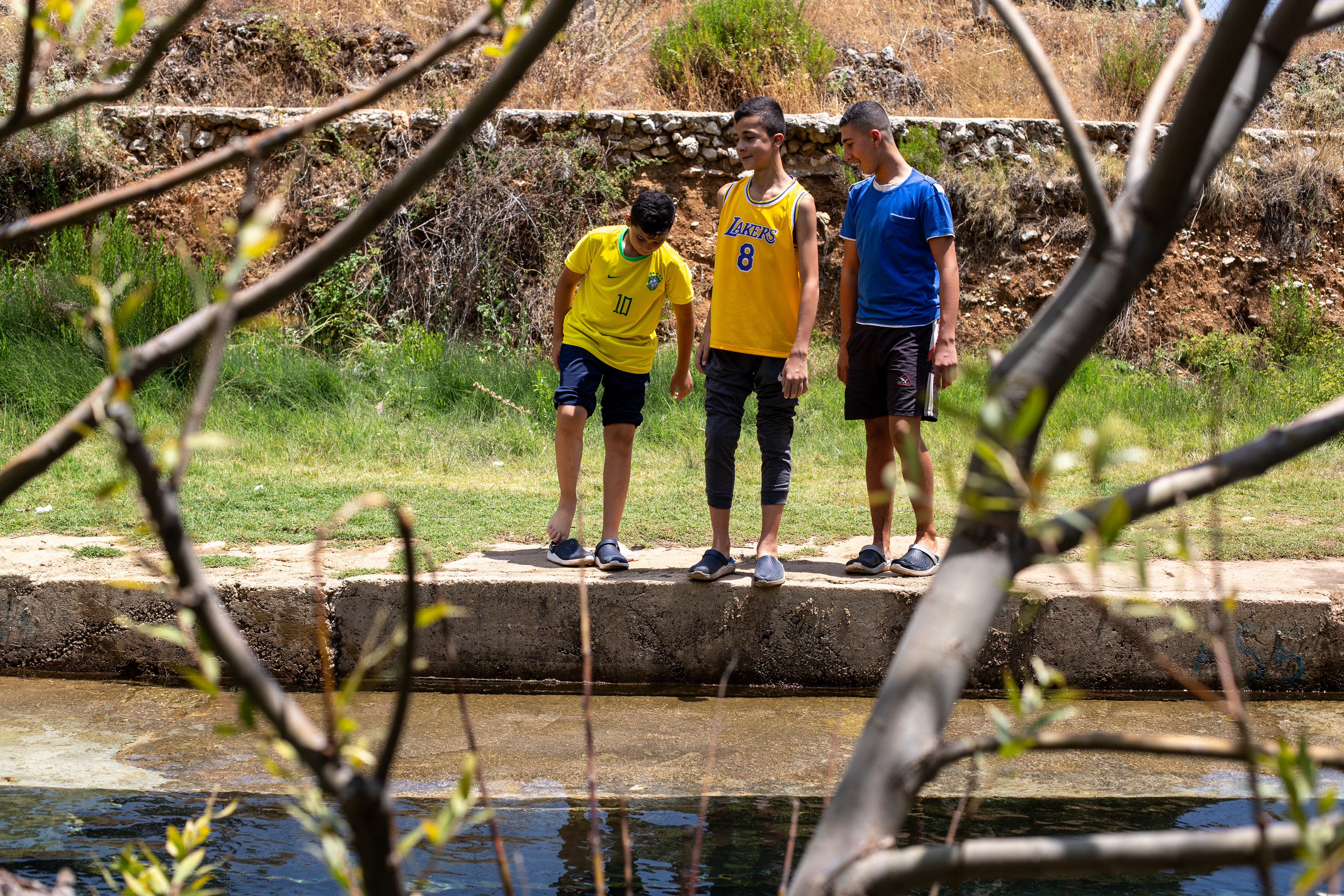 The sons of the landowner play in the stream at the entrance of the farm. In the summer, landlords often return from abroad with their families.