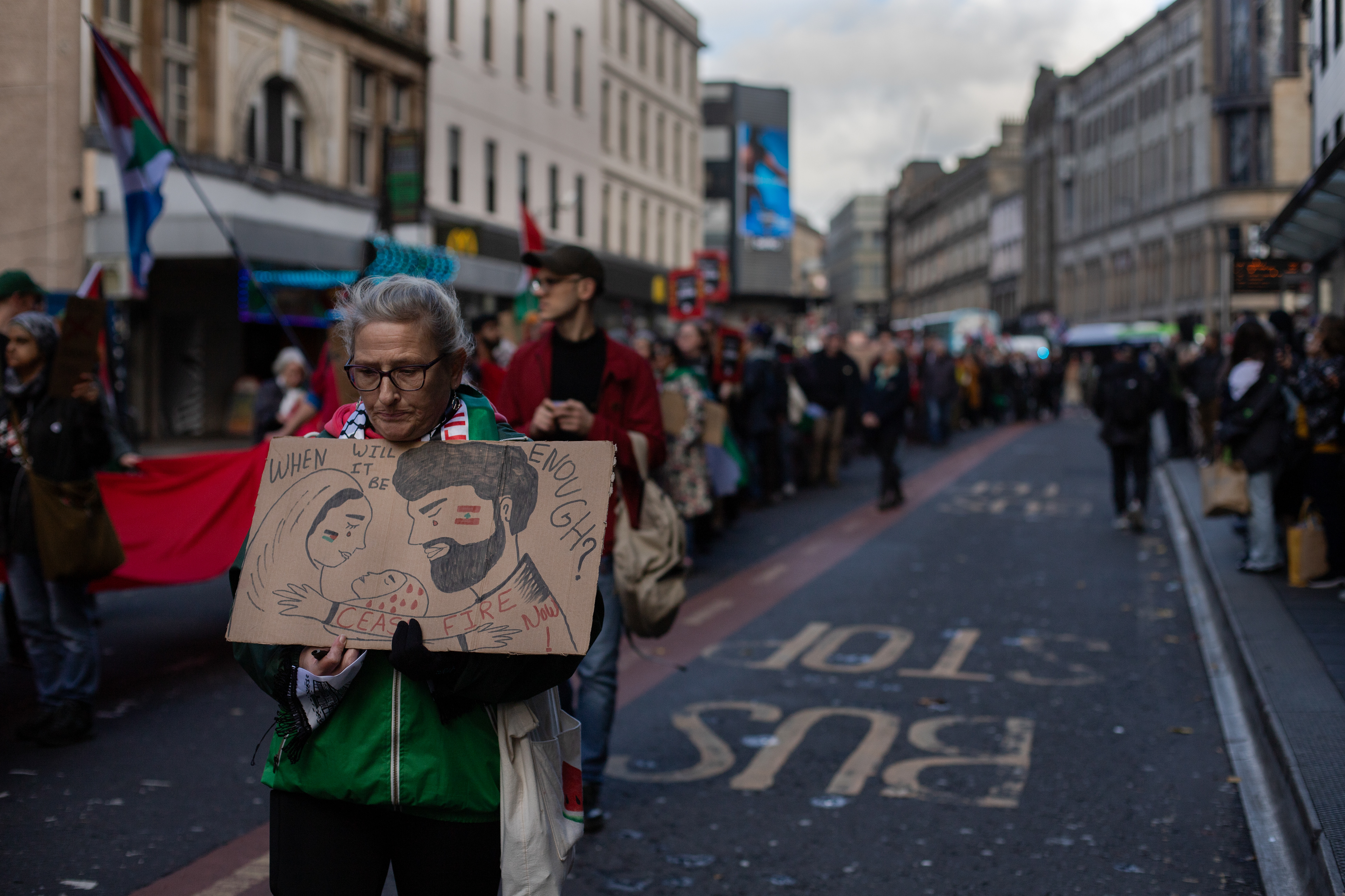 A protester carries a sign reading 'When will it be enough?’ during a pro-Palestinian march in Glasgow on October 26, 2024.