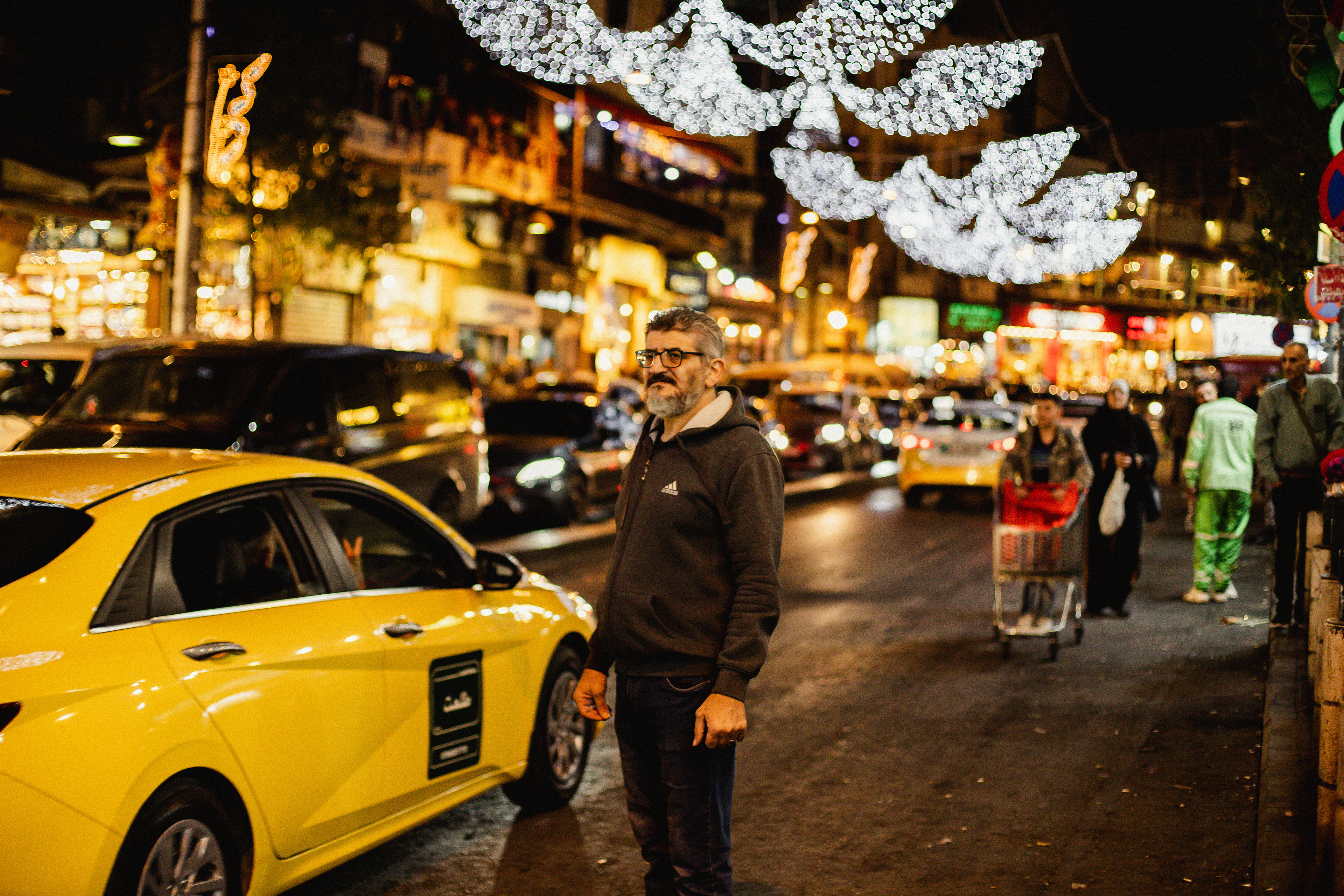 A man waits to cross the busy street in the Balad.