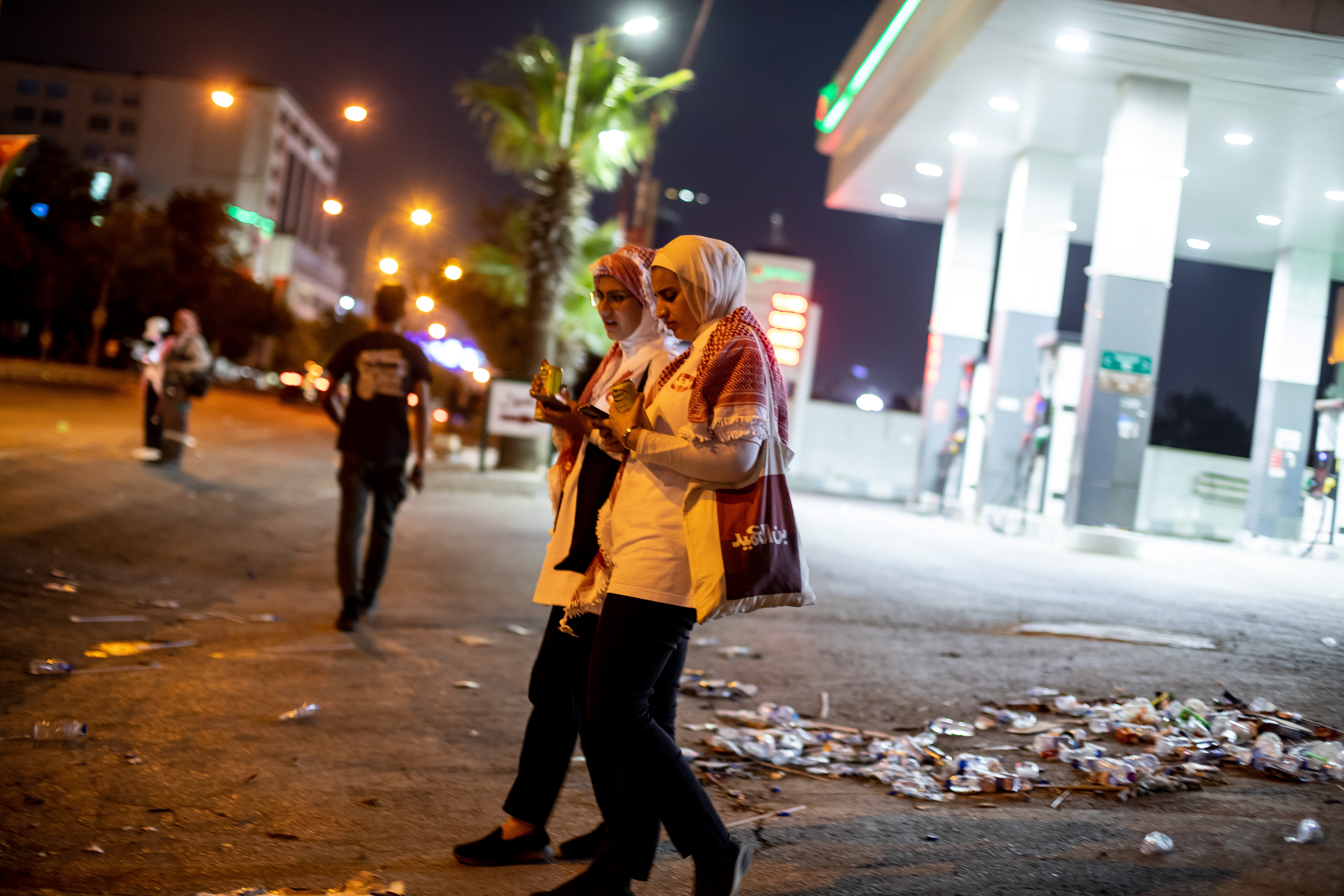 Two young women walk past trash, the aftermath of the crowds which hours before had filled the streets waiting to catch a glimpse of the Prince and Princess on their wedding day.