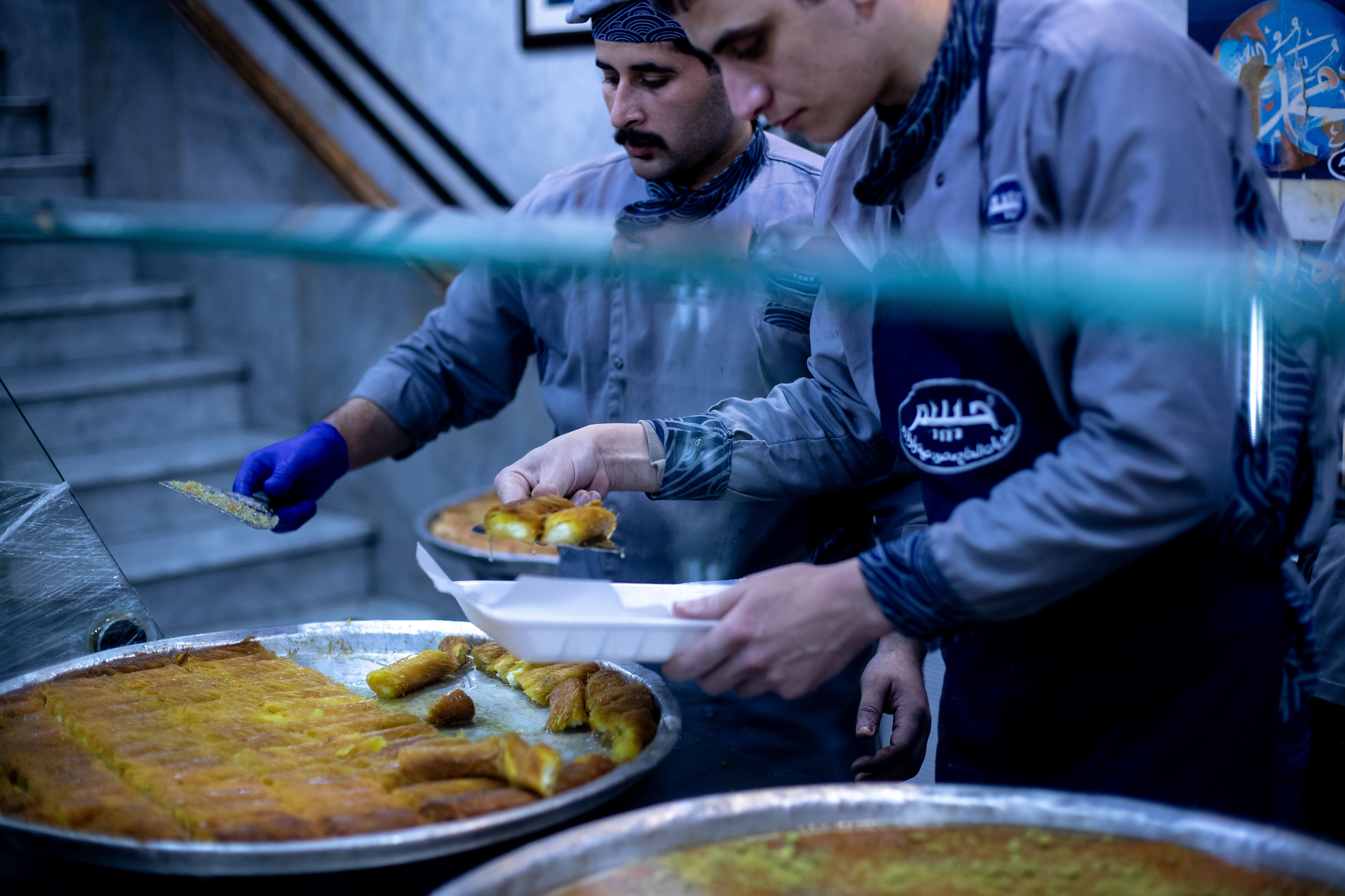 Workers in the sweet shop named Habibah serve customers.