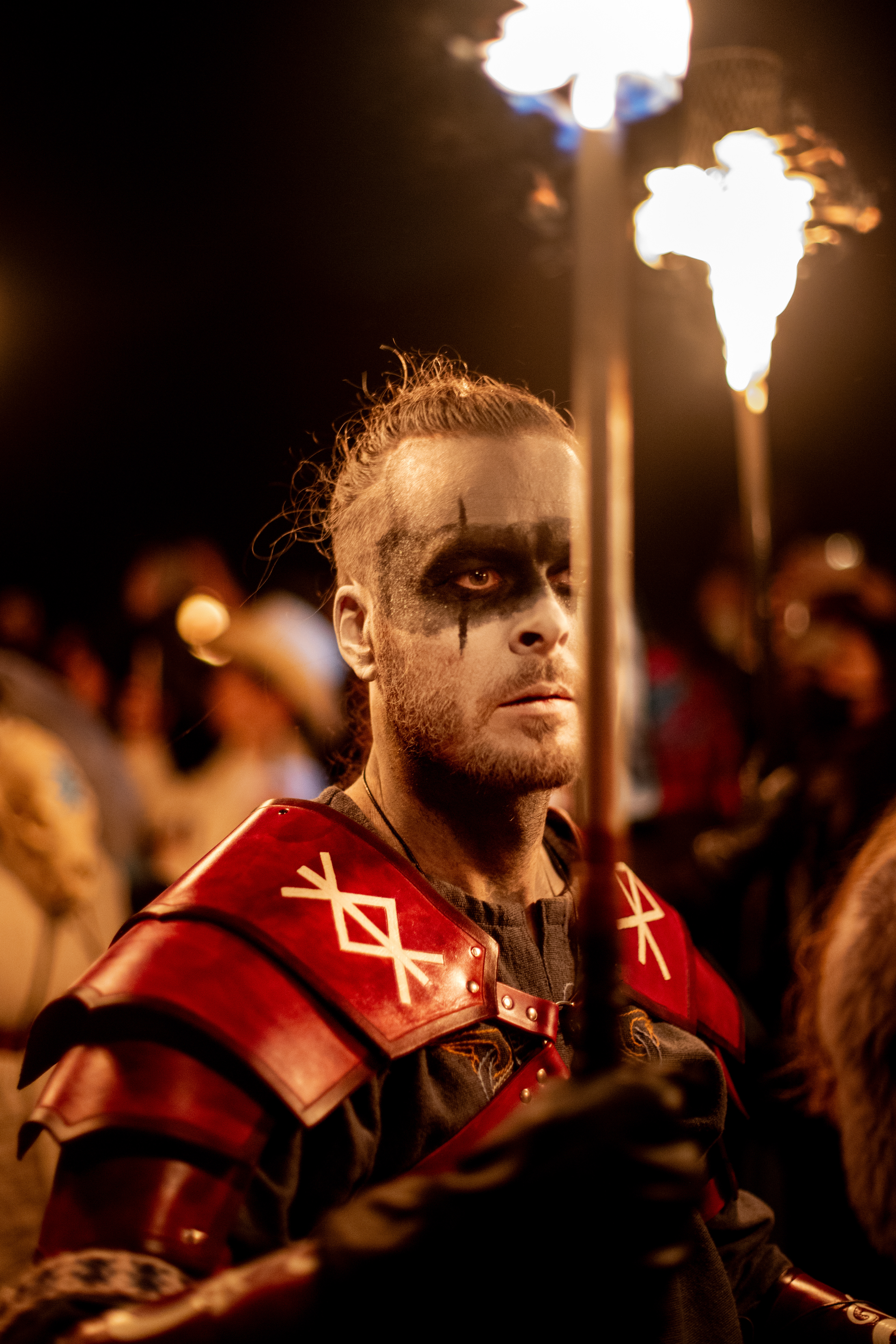 A performer at the festival walks in a procession holding a lit torch. Fire plays an important role in the festival which celebrates the overthrowing of the Summer King by the Winter King.
