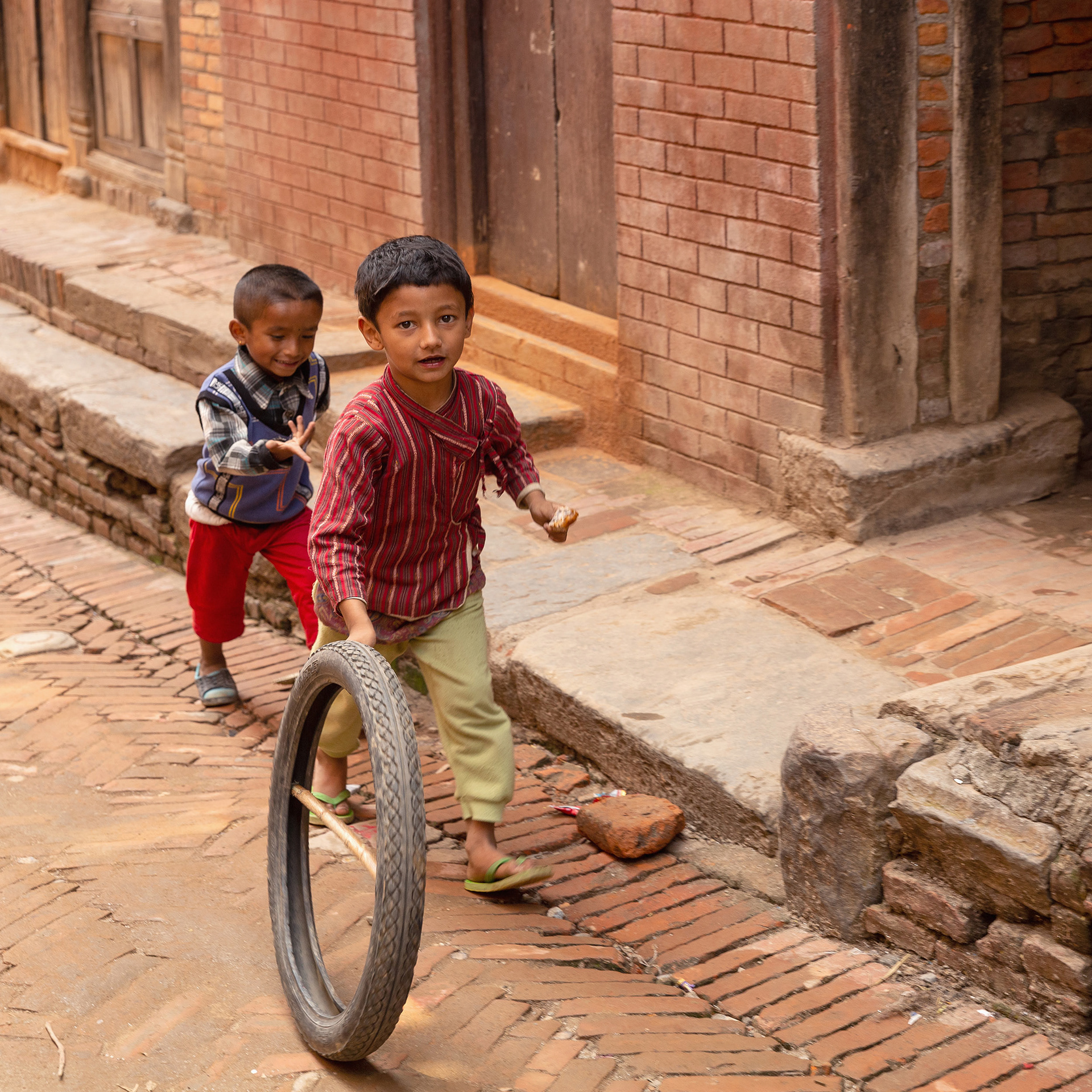 Children playing with tire in Bhaktapur, Nepal {040118_Nepal_0895}