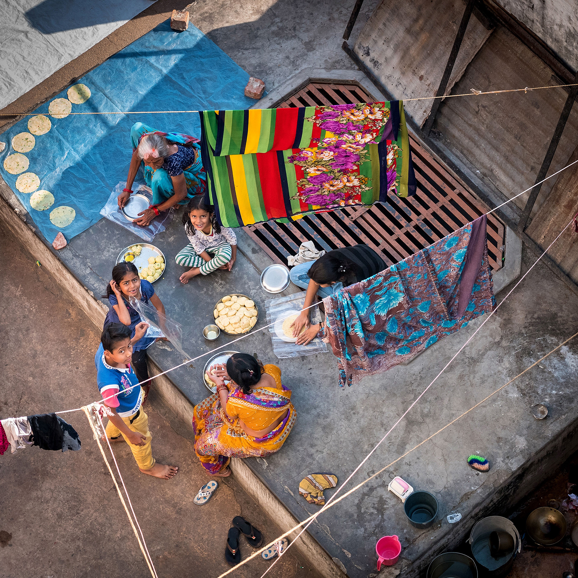 Family making chapati on rooftop in Varanasi, India {030517_Varanasi_528}