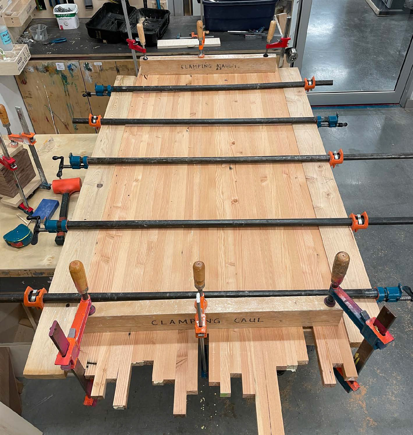 After jointing and planing the wood, we laminated them together to create wood panels.