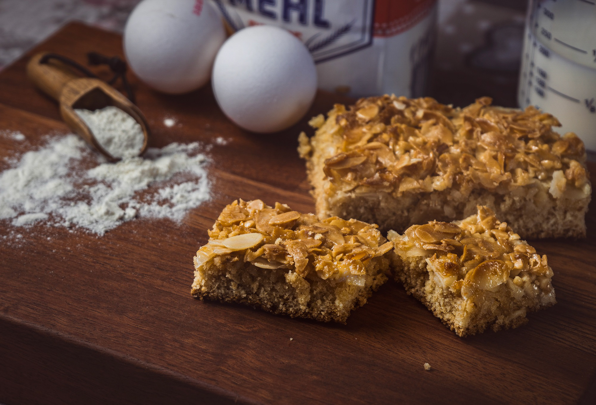 Hausgemachter Mandelkuchen, inszeniert mit Backzutaten und natürlichem Licht.