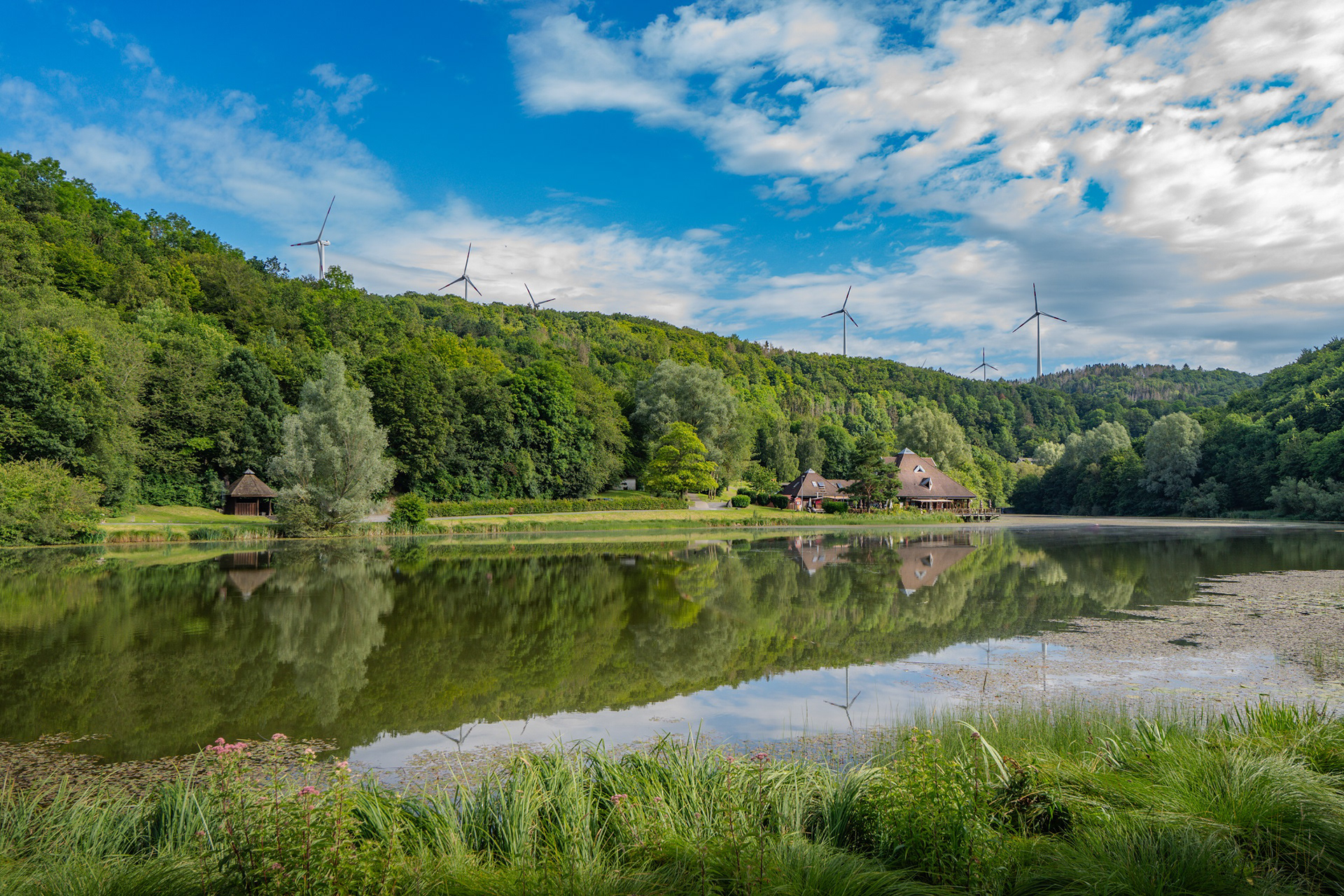 Außenaufnahme mit Blick auf die umliegende Landschaft und See bei Sonnenschein.