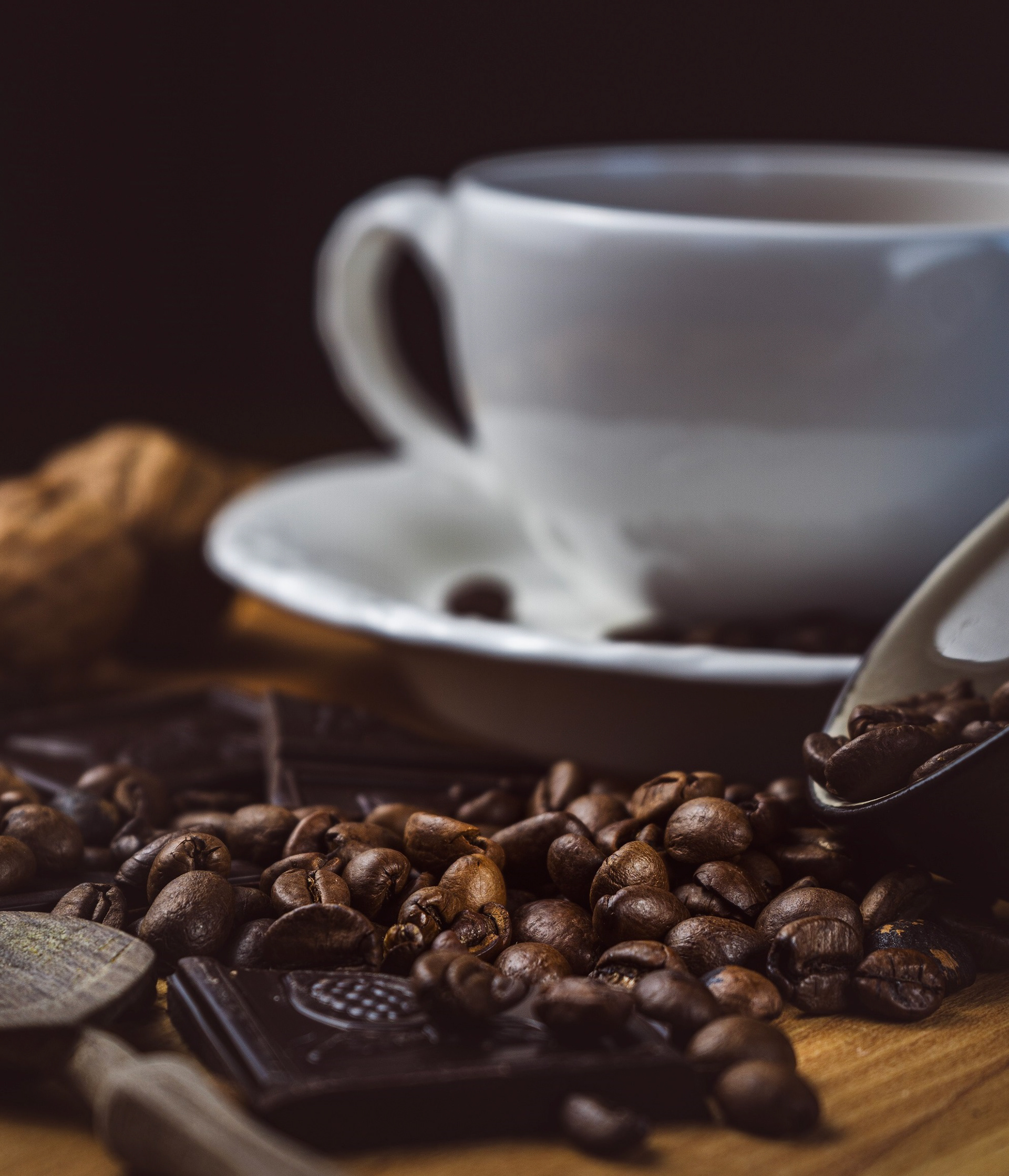 Kaffee-Stillleben mit Bohnen und dunkler Schokolade – warme, kontrastreiche Lichtstimmung