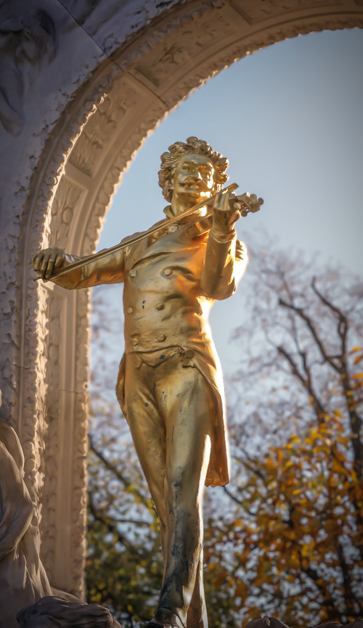 Eine bronzene Figur zwischen Sonne und Schatten
