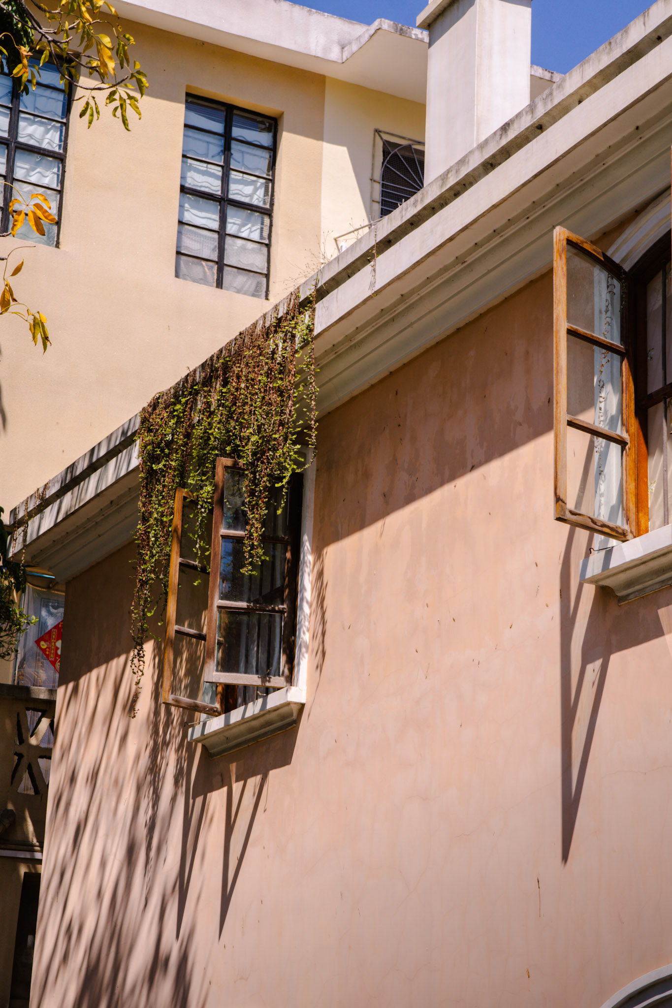 Sonnige Hauswand mit offener Fensterklappe