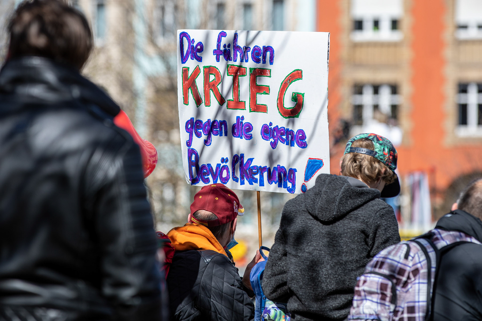 A protester holds a placard reading 'They are at war against their own population' during a demonstration held by the 'Querdenker' (lateral thinkers) movement against the German government's coronavirus restrictions in Stuttgart, Germany, 03 April 2021. Stuttgart is the center of the 'Querdenker' movement, founded by entrepreneur Michael Ballweg, as the broadest possible grouping against the government's COVID-19 measures. The police is deployed with several hundred units while thousands are protesting. EPA-EFE/CONSTANTIN ZINN