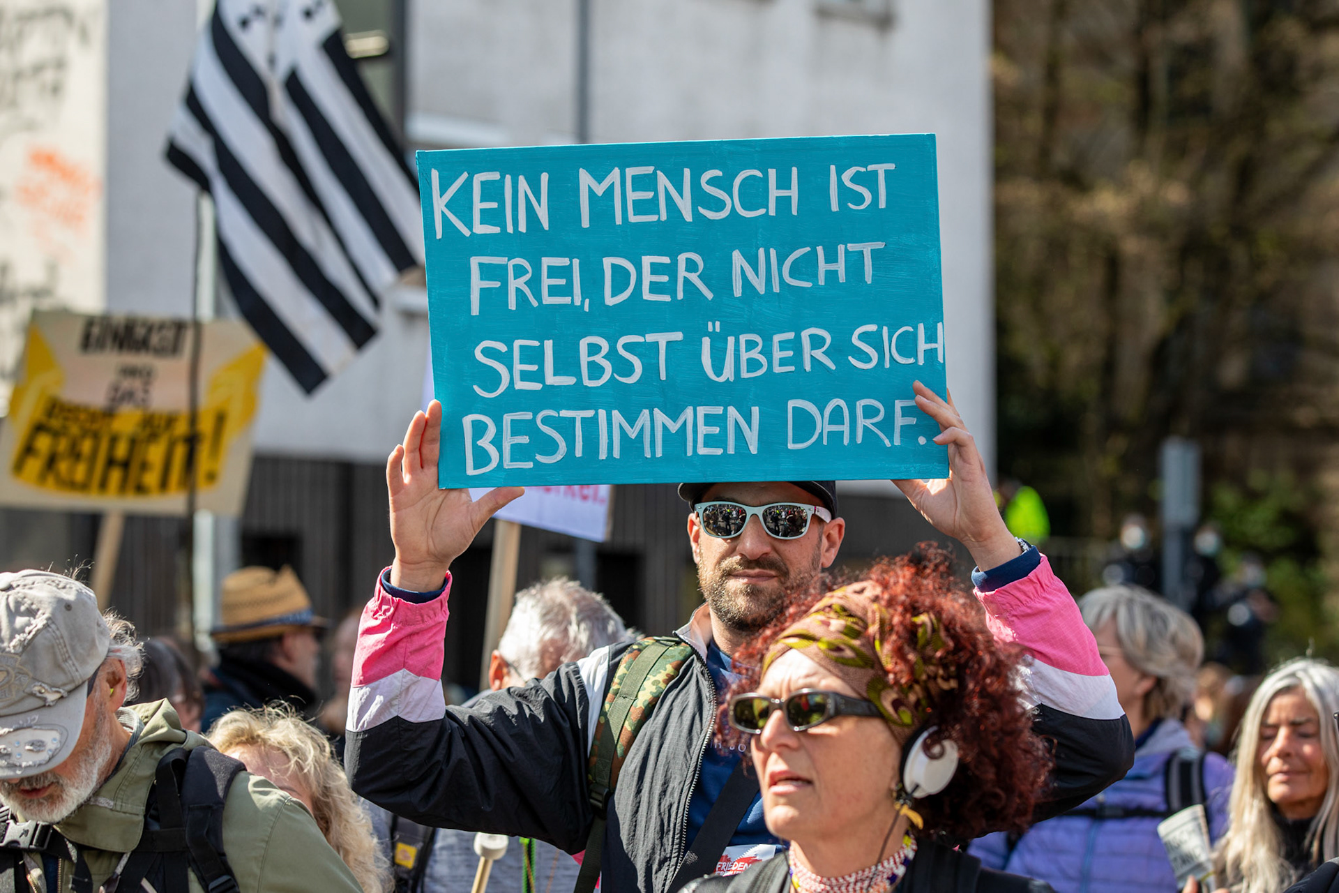 A protester holds a placard reading 'No person is free who is not allowed to determine their own lives' during a demonstration held by the 'Querdenker' (lateral thinkers) movement against the German government's coronavirus restrictions in Stuttgart, Germany, 03 April 2021. Stuttgart is the center of the 'Querdenker' movement, founded by entrepreneur Michael Ballweg, as the broadest possible grouping against the government's COVID-19 measures. The police is deployed with several hundred units while thousands are protesting. EPA-EFE/CONSTANTIN ZINN