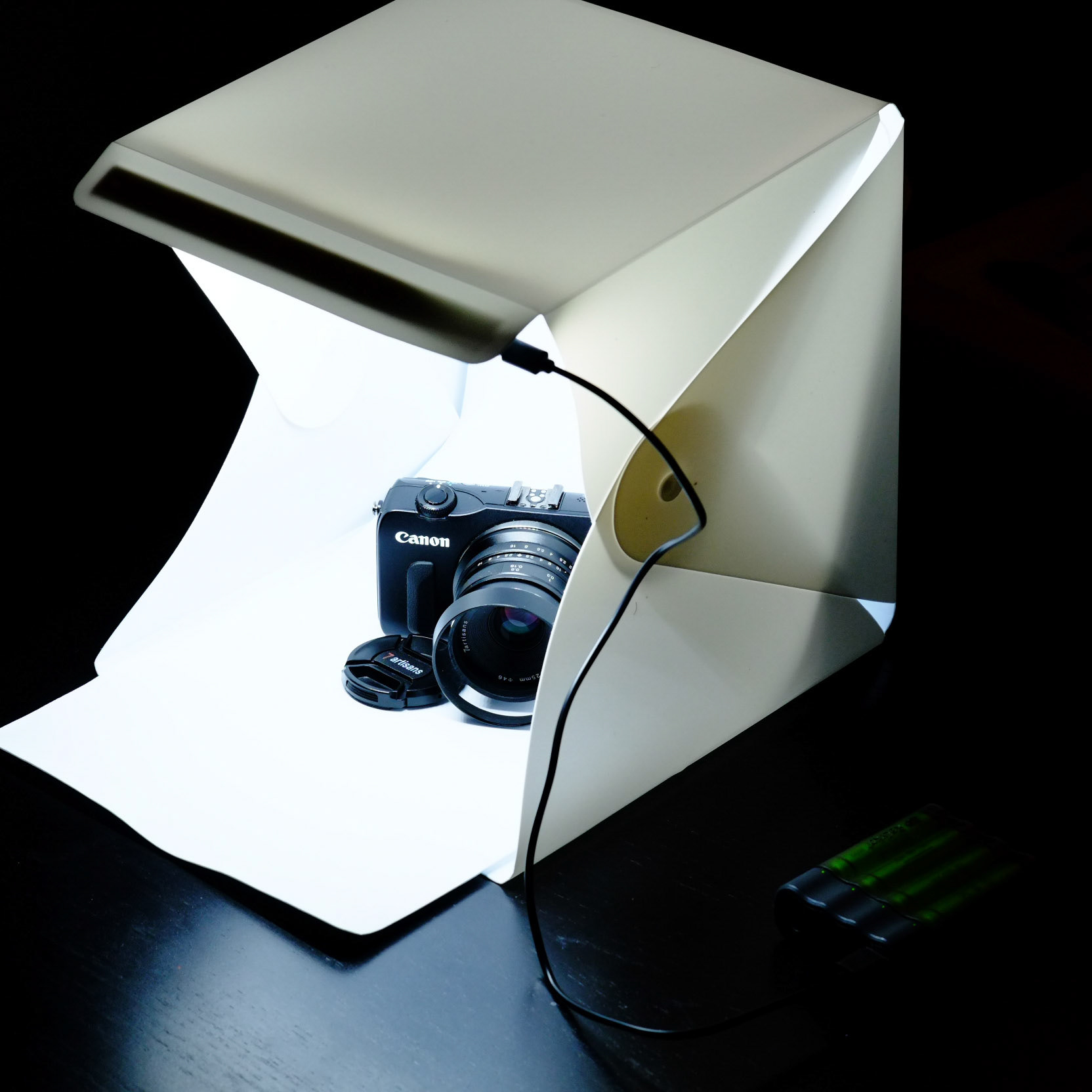 This is the entire kit used for these photos. Obviously, this shot and the other of the Canon is shot using a different camera. The USB-powered lightbox was $23 on eBay, came with this white backdrop, and a darker one, the powerbank is just one I had lying around.