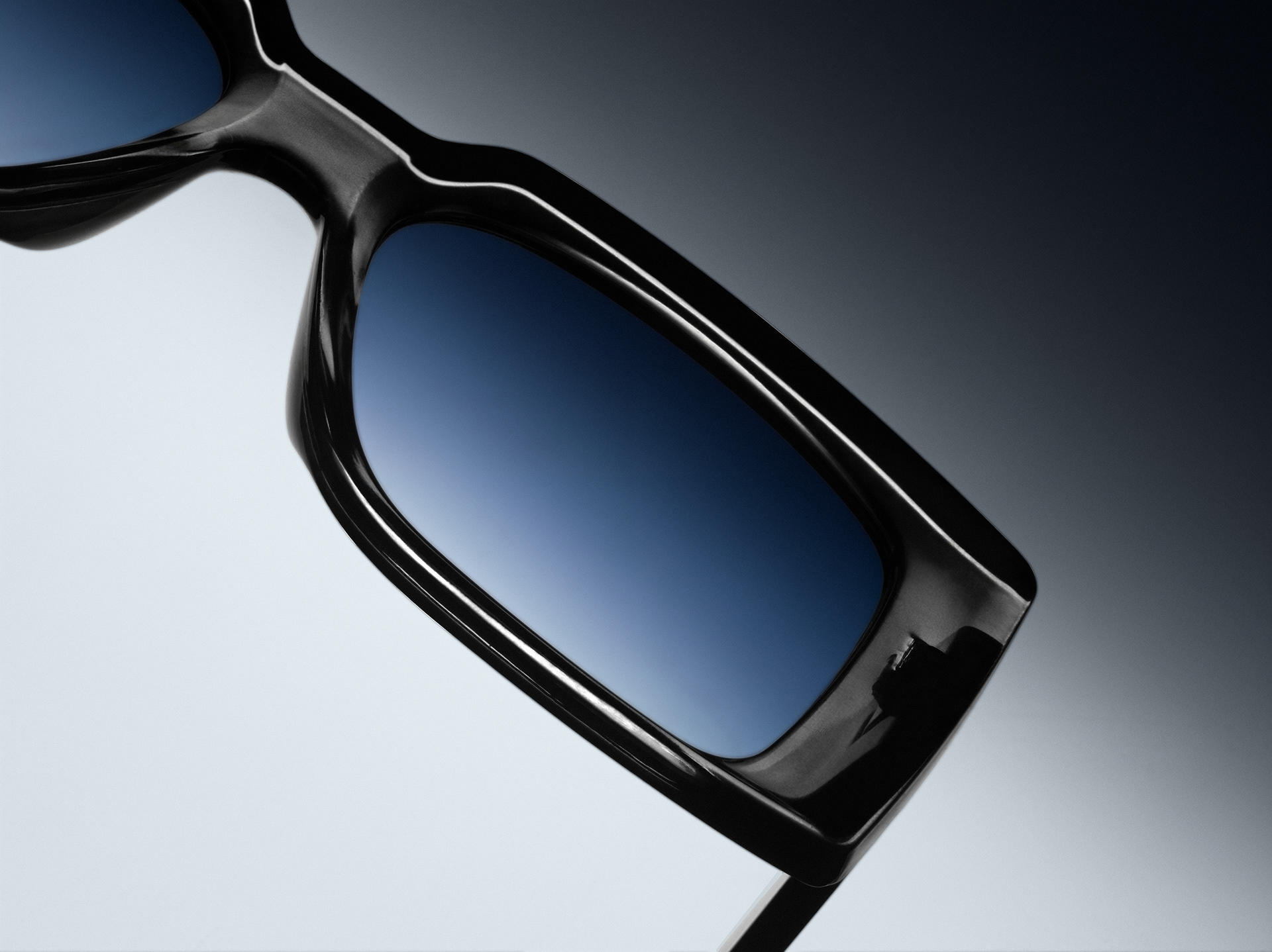 Sleek sunglasses placed on a smooth gradient background, showcasing a stylish and modern design.