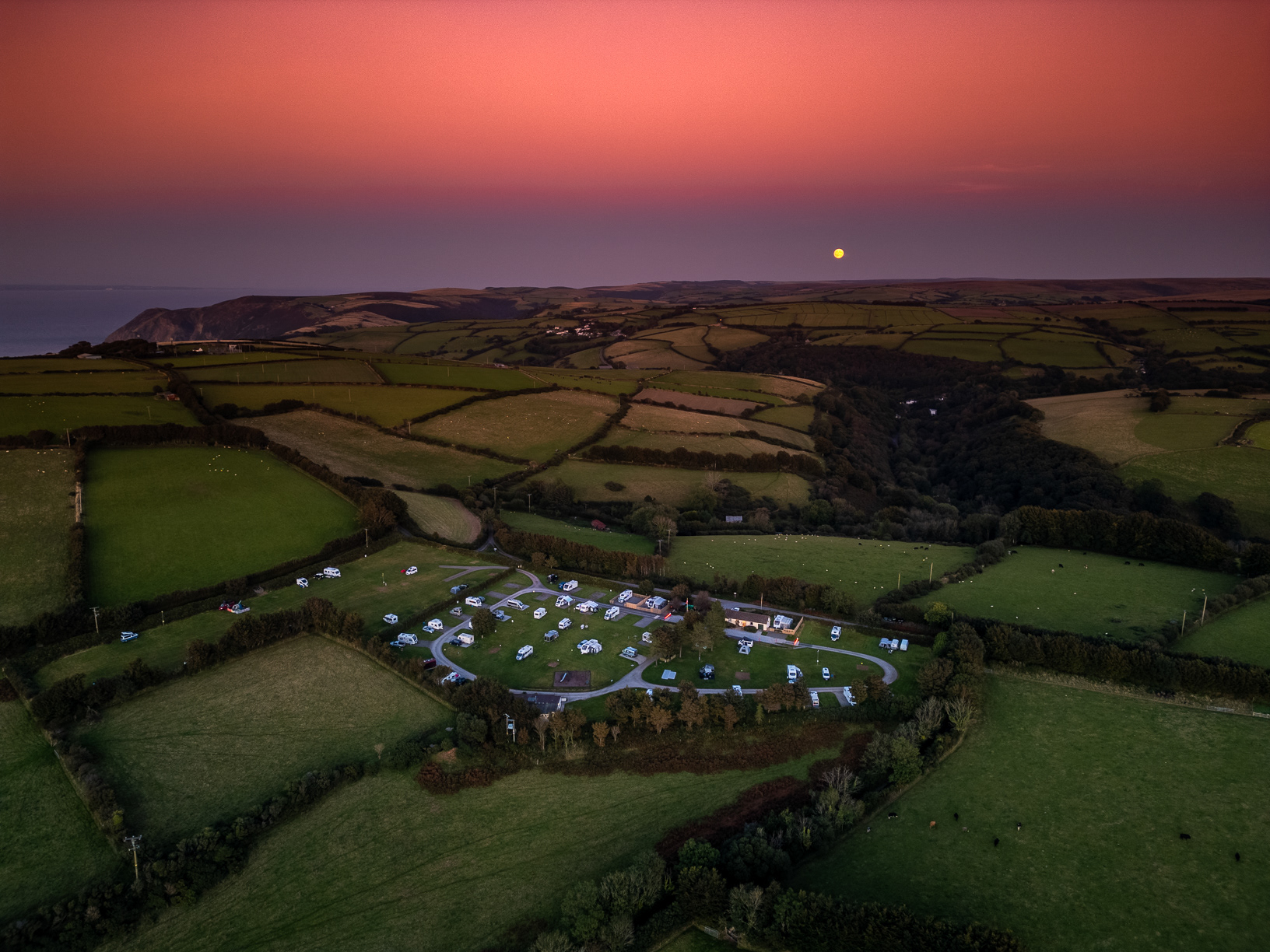 Harvest Moon rising against a reflected sunset