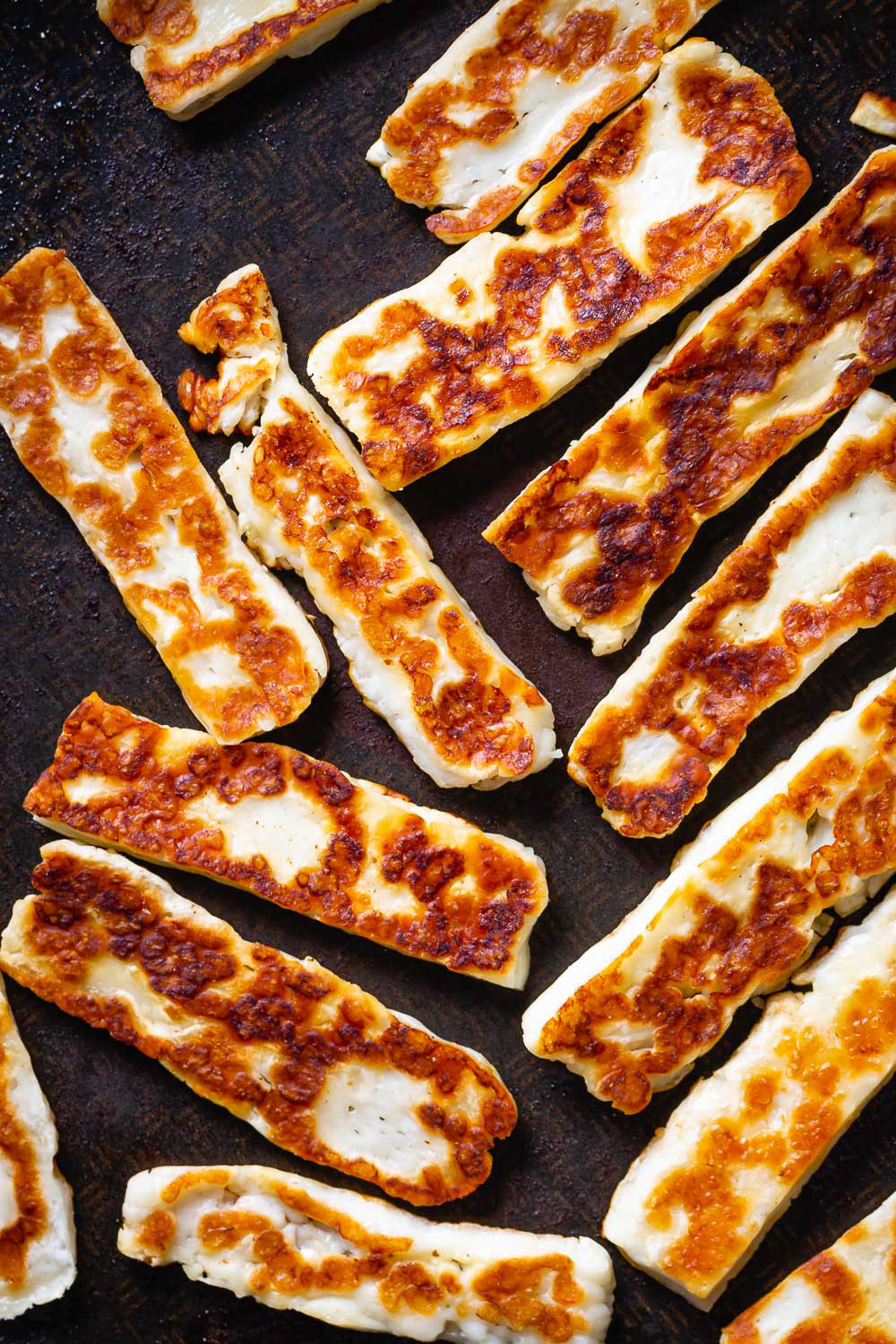 Dark and moody macro shot of fried halloumi cheese